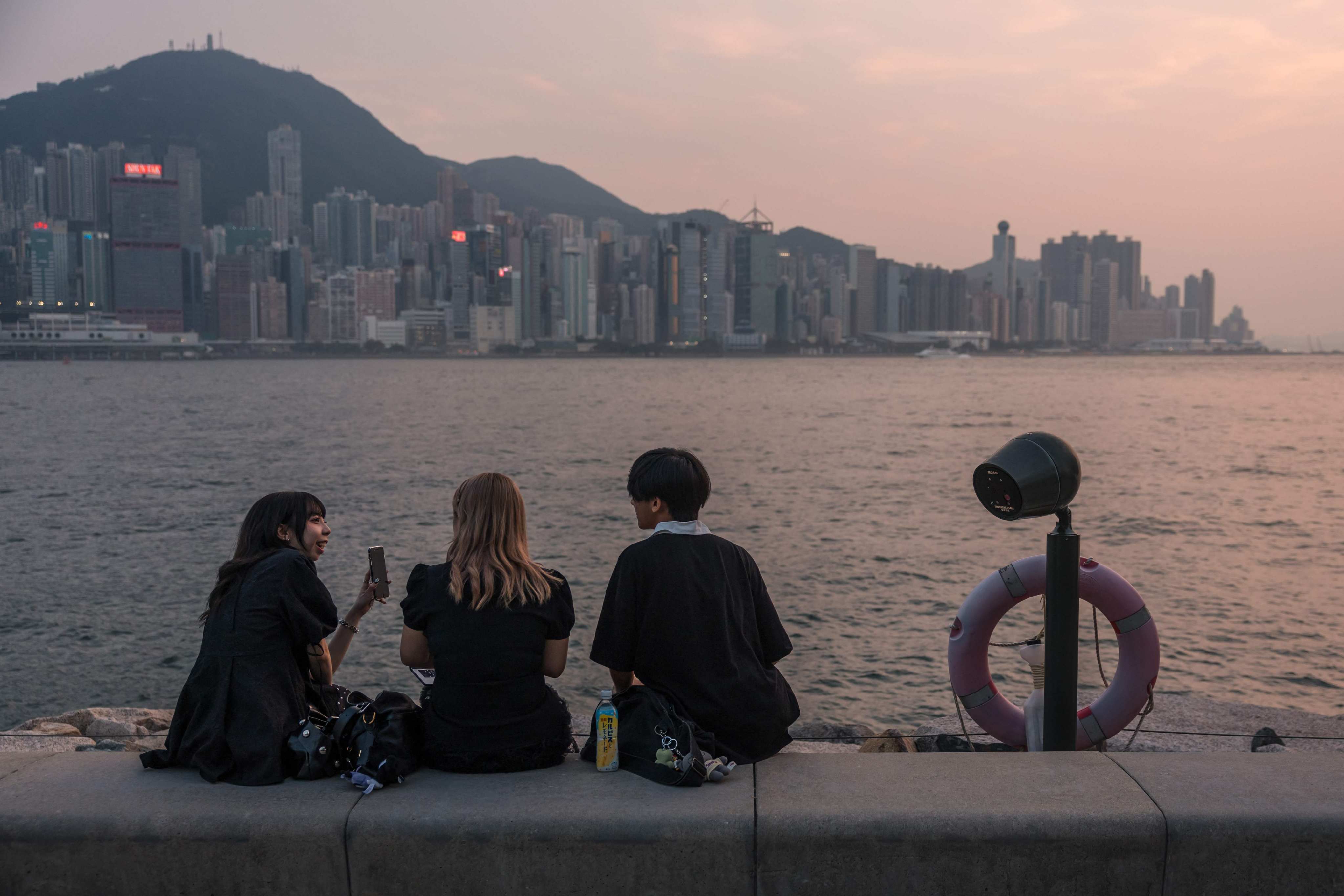 People sit on a promenade next to Victoria Harbour in Hong Kong on September 8.  The city is uniquely positioned to support the national effort to construct alternative financial and technological ecosystems. Photo: AFP