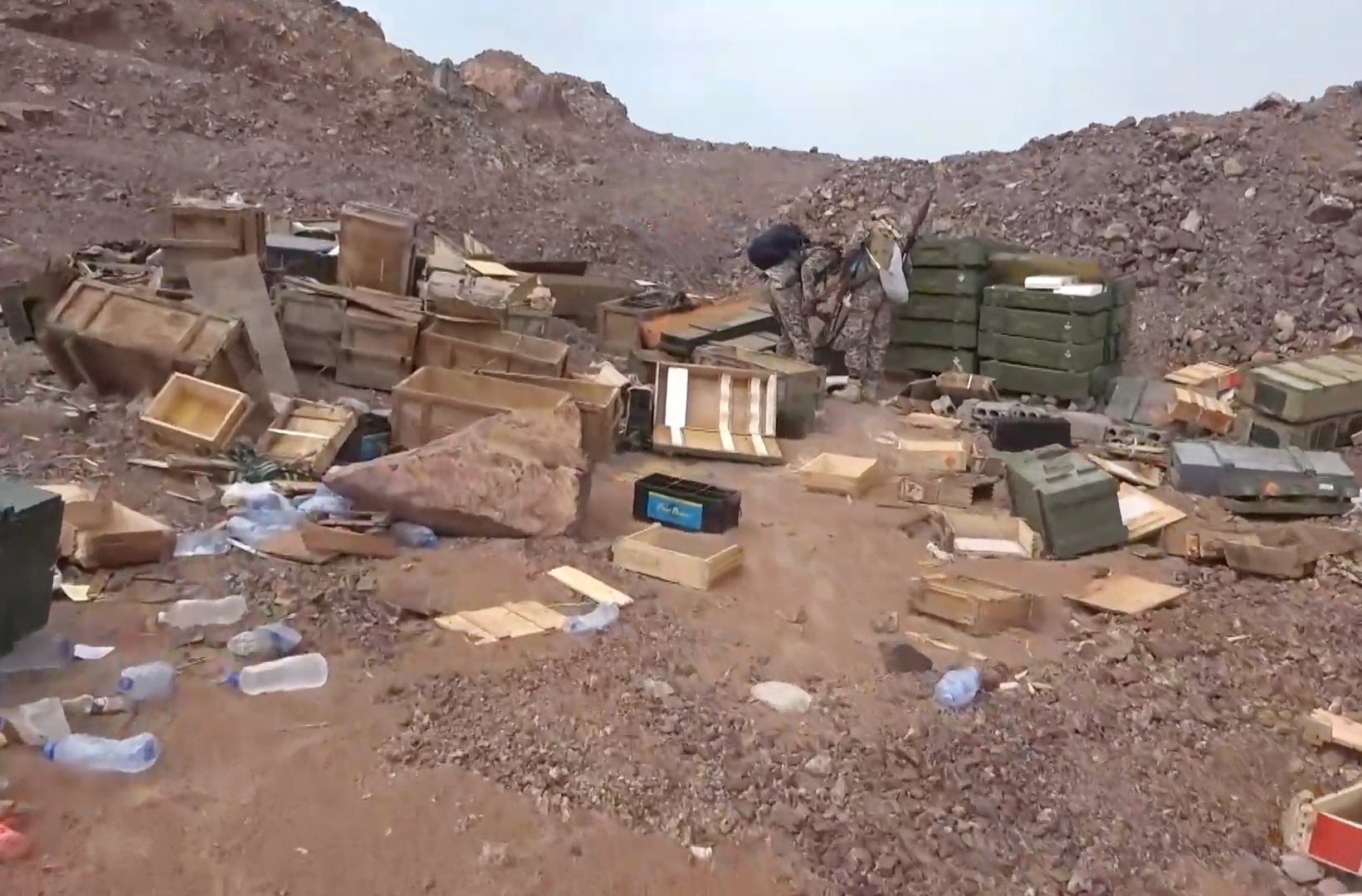 Houthi fighters inspecting ammunition boxes at a seized camp. Photo: Houthi Military Media via EPA