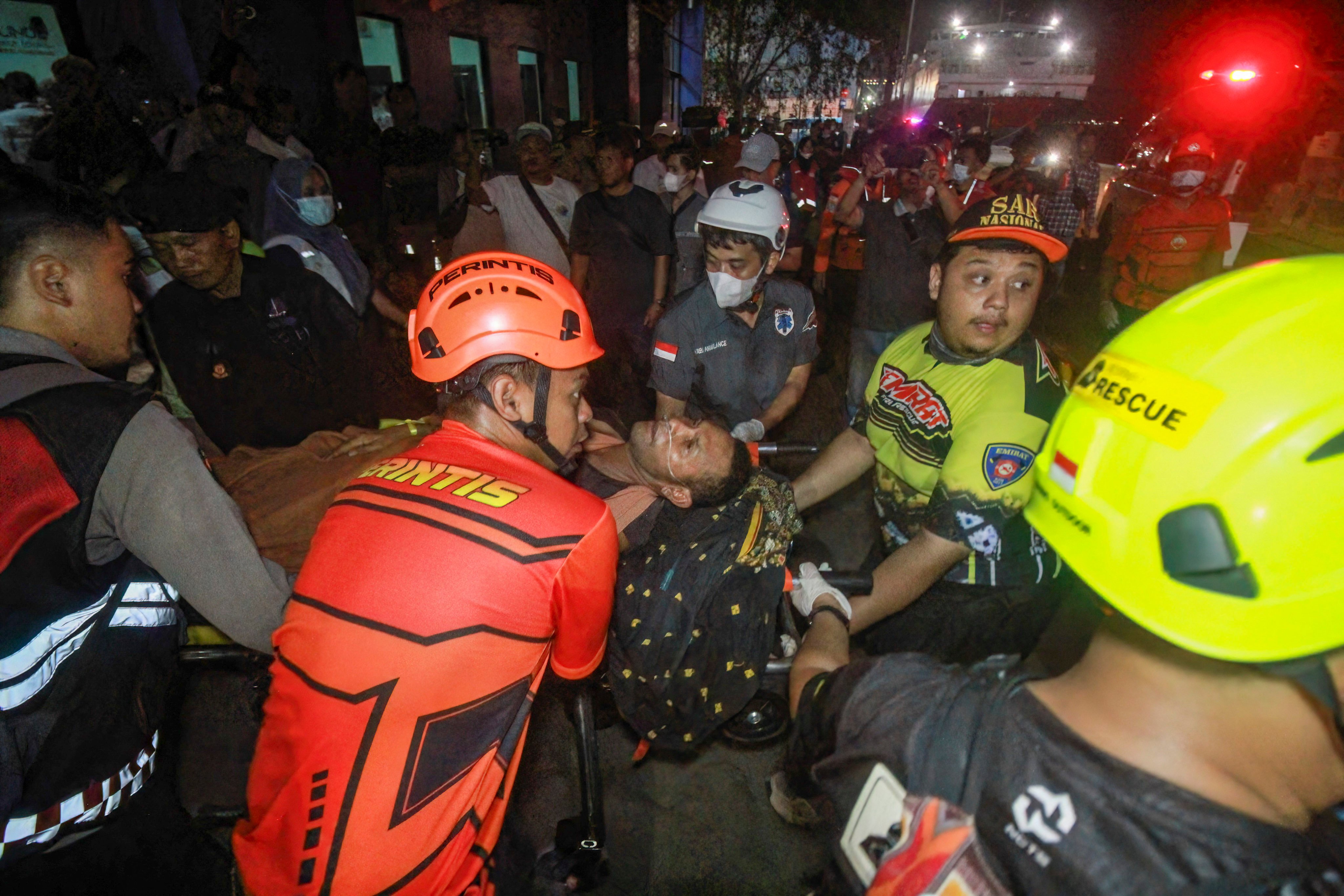 Rescue teams evacuate a victim of the Virgo Transport 8 passenger ferry, which capsized while carrying 243 people on its route to Banjarmasin from Surabaya, to a hospital in Banjarmasin, South Kalimantan on September 13, 2026. Rescuers in Indonesia said at least six people were killed and 130 others were missing on September 13 after a ferry sailing between the islands of Java and Borneo was hit by bad weather and capsized. (Photo by INFUZ / AFP)