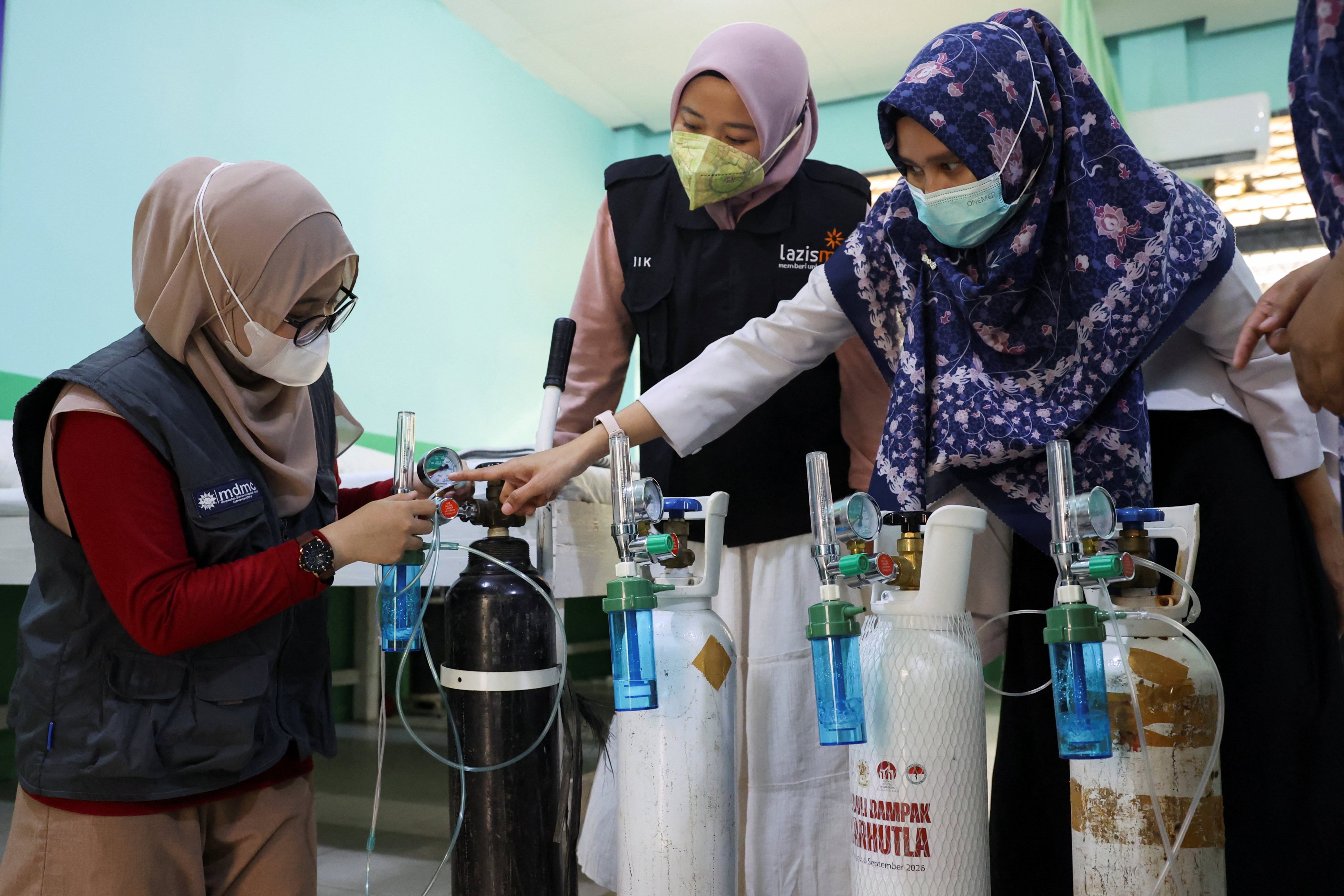 Volunteers from "Rumah Oksigen" (Oxygen House) check an oxygen cylinder used to provide oxygen assistance to residents affected by haze from wildfires in Pontianak, West Kalimantan province, Indonesia, September 14, 2026. REUTERS/Ajeng Dinar Ulfiana