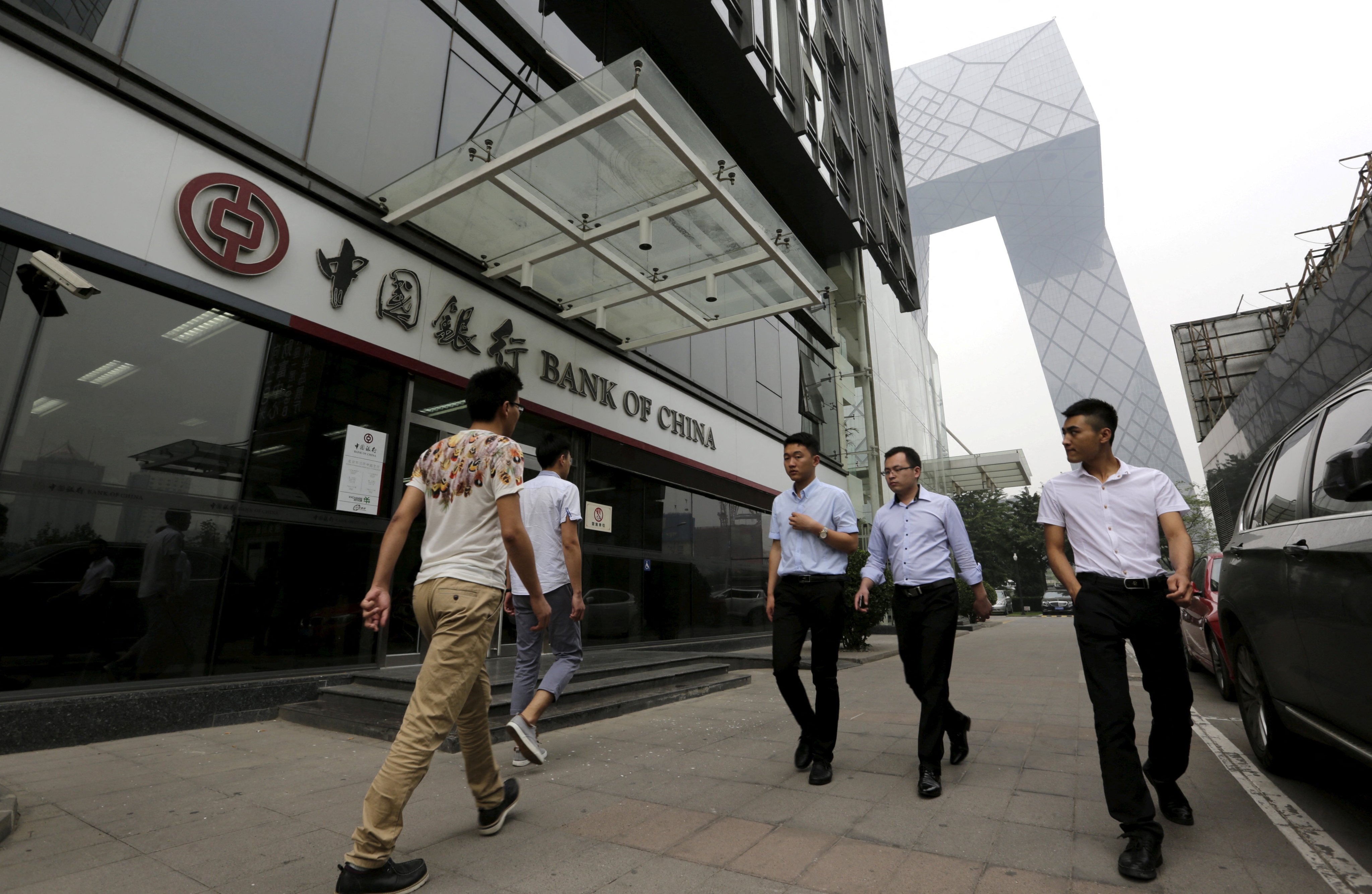 Pedestrians walk past a branch of Bank of China in Beijing. Photo: Reuters