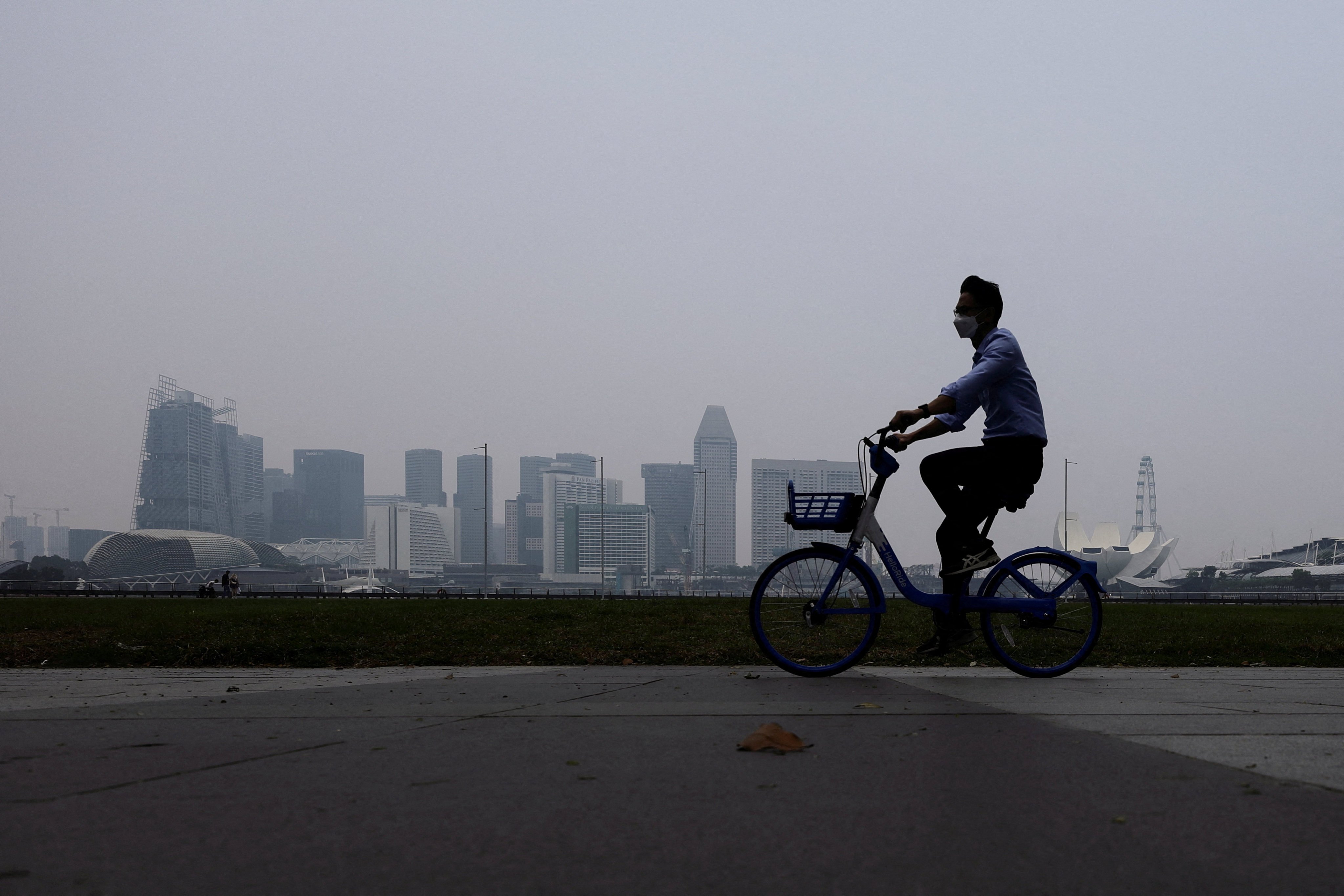 A cyclist rides along the bayfront with Singapore’s skyline shrouded in haze on Monday. Photo: Reuters