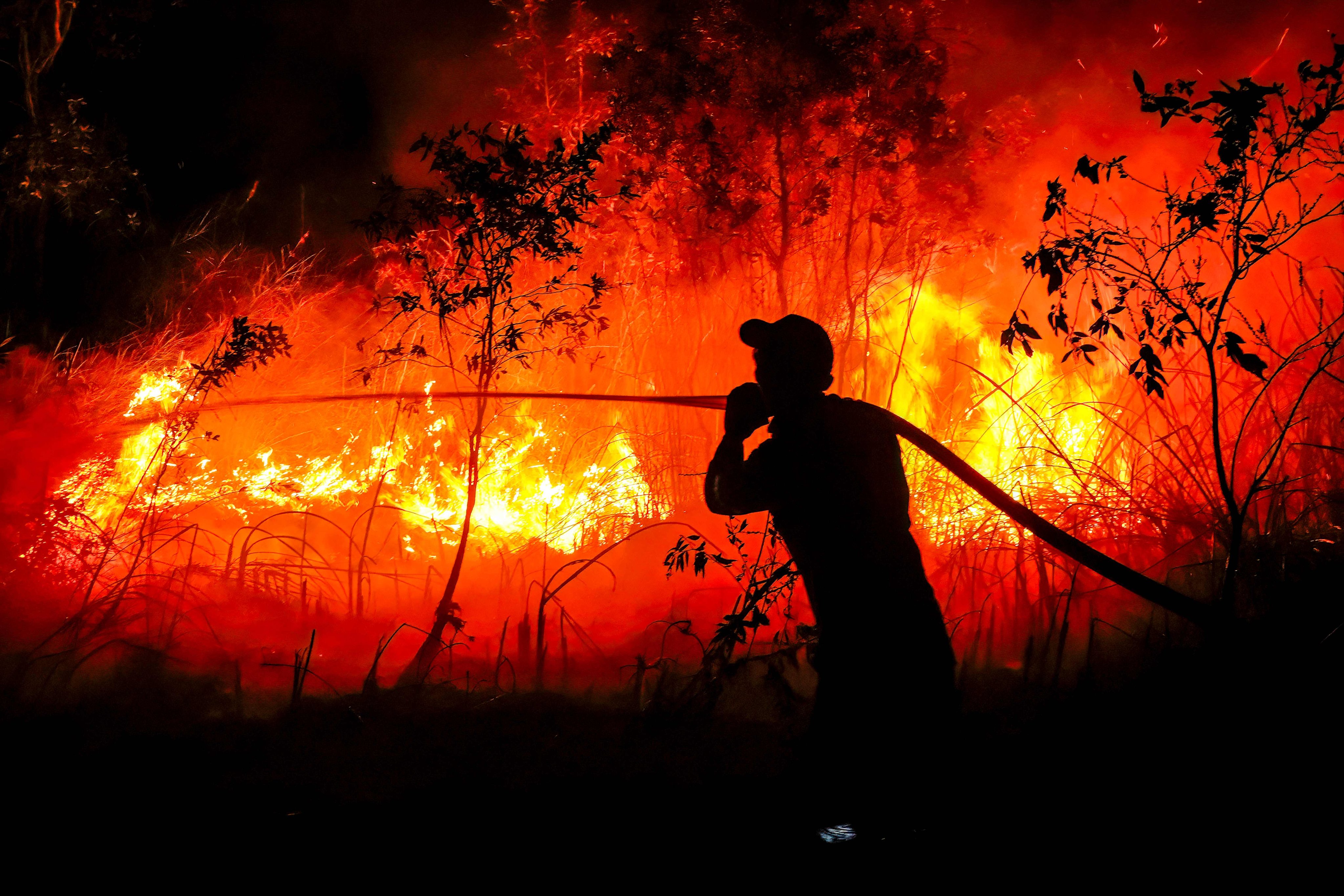 An Indonesian firefighter douses a forest fire at Sungai Rambutan village in Ogan Ilir, South Sumatra, on Friday. Photo: AFP
