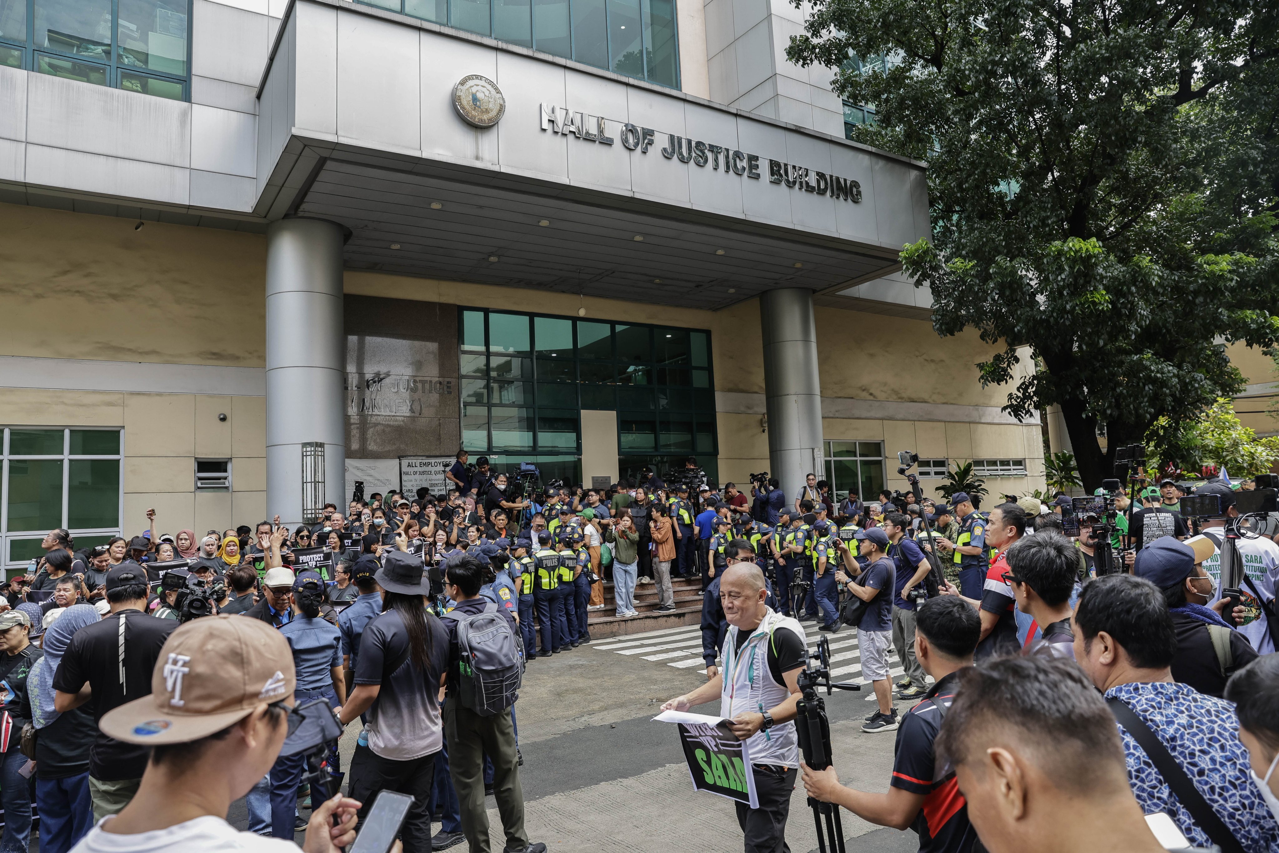 Police keep watch on supporters of Philippine Vice-President Sara Duterte-Carpio outside the Hall of Justice in Quezon City, Metro Manila, on Friday. Photo: EPA