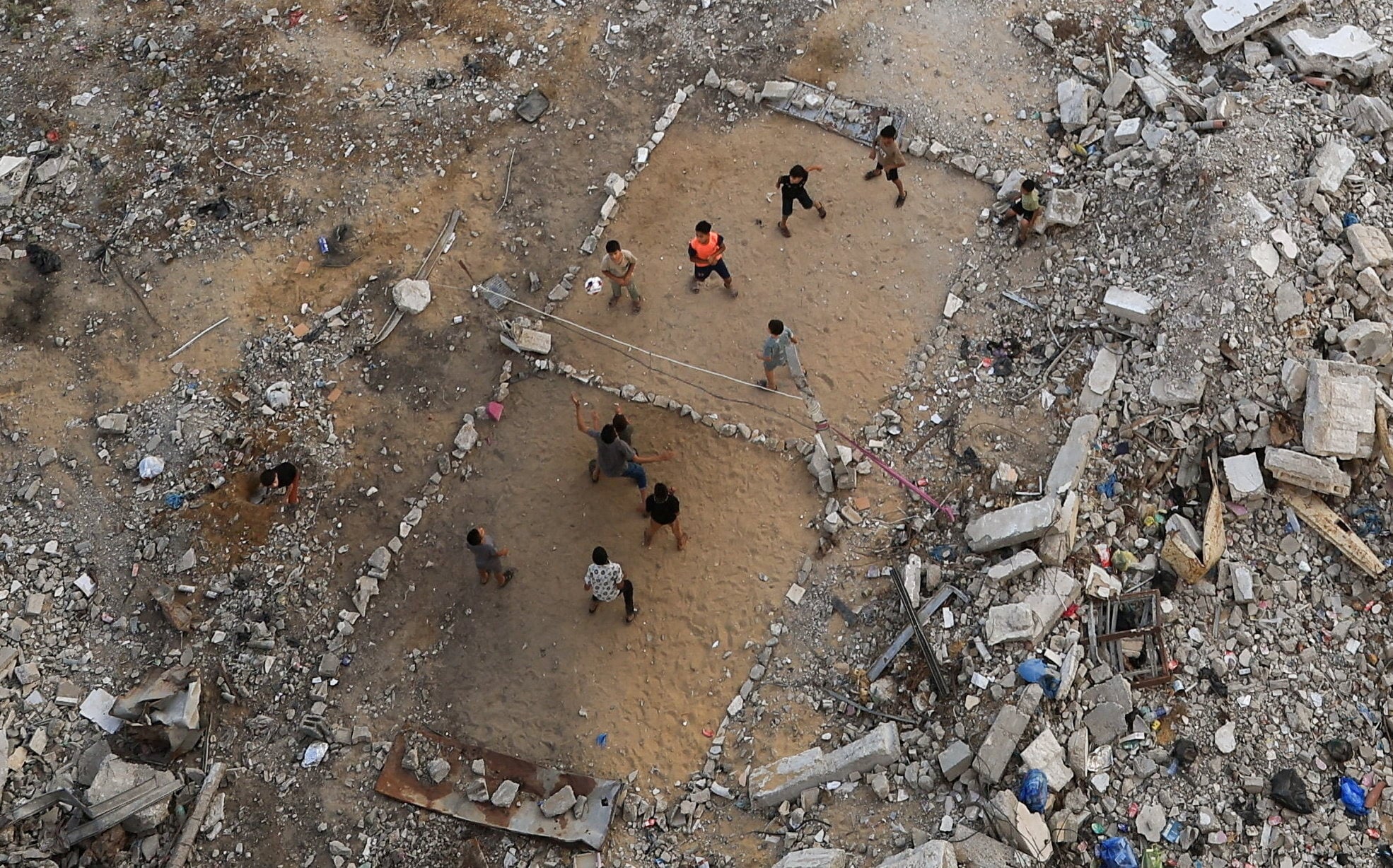 Palestinian children play volleyball amid the rubble of destroyed buildings in Gaza City. Photo: Reuters