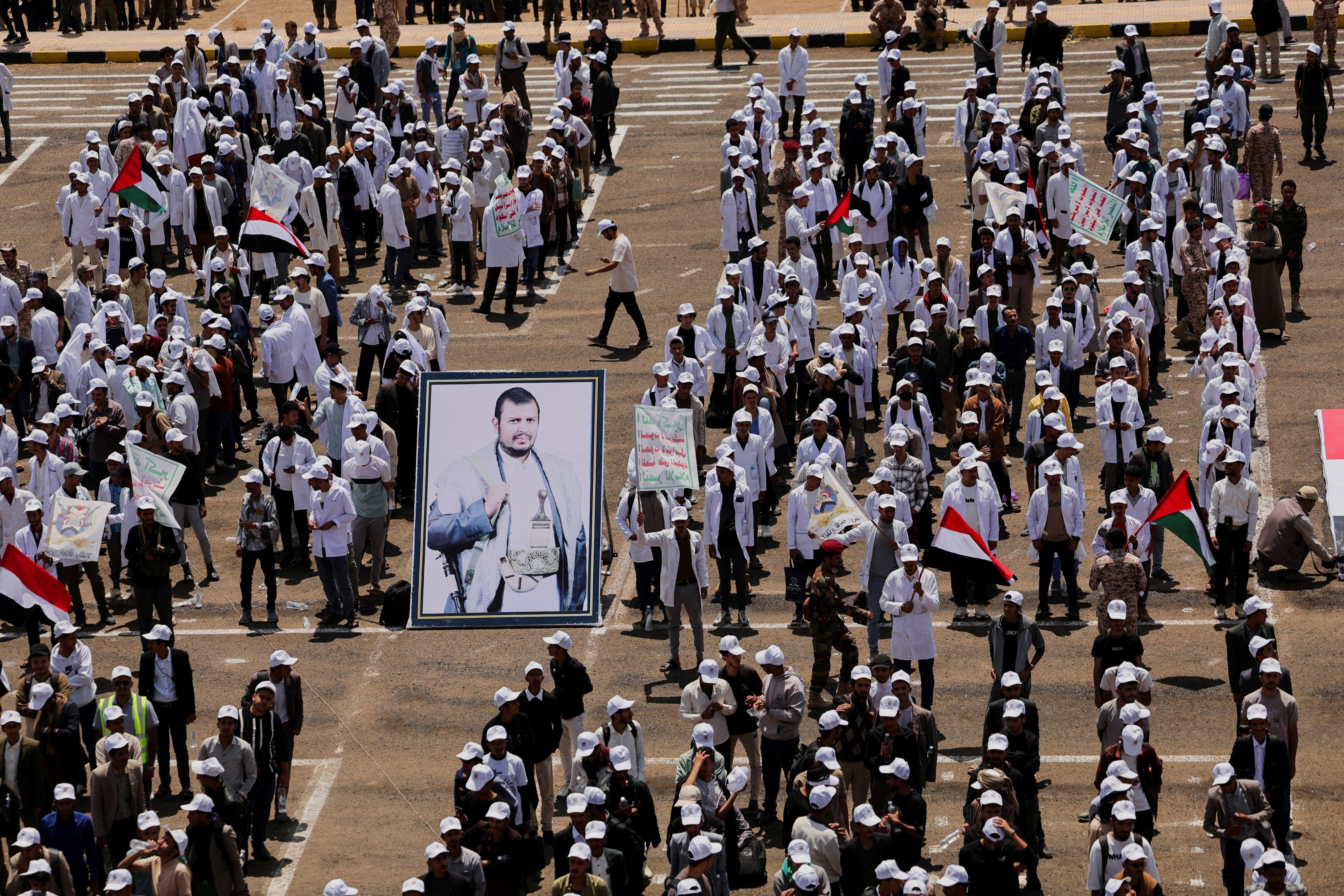 Students stand next to a poster of Houthi leader Abdul Malik al-Houthi in Sanaa, Yemen, on July 22. Photo: Reuters