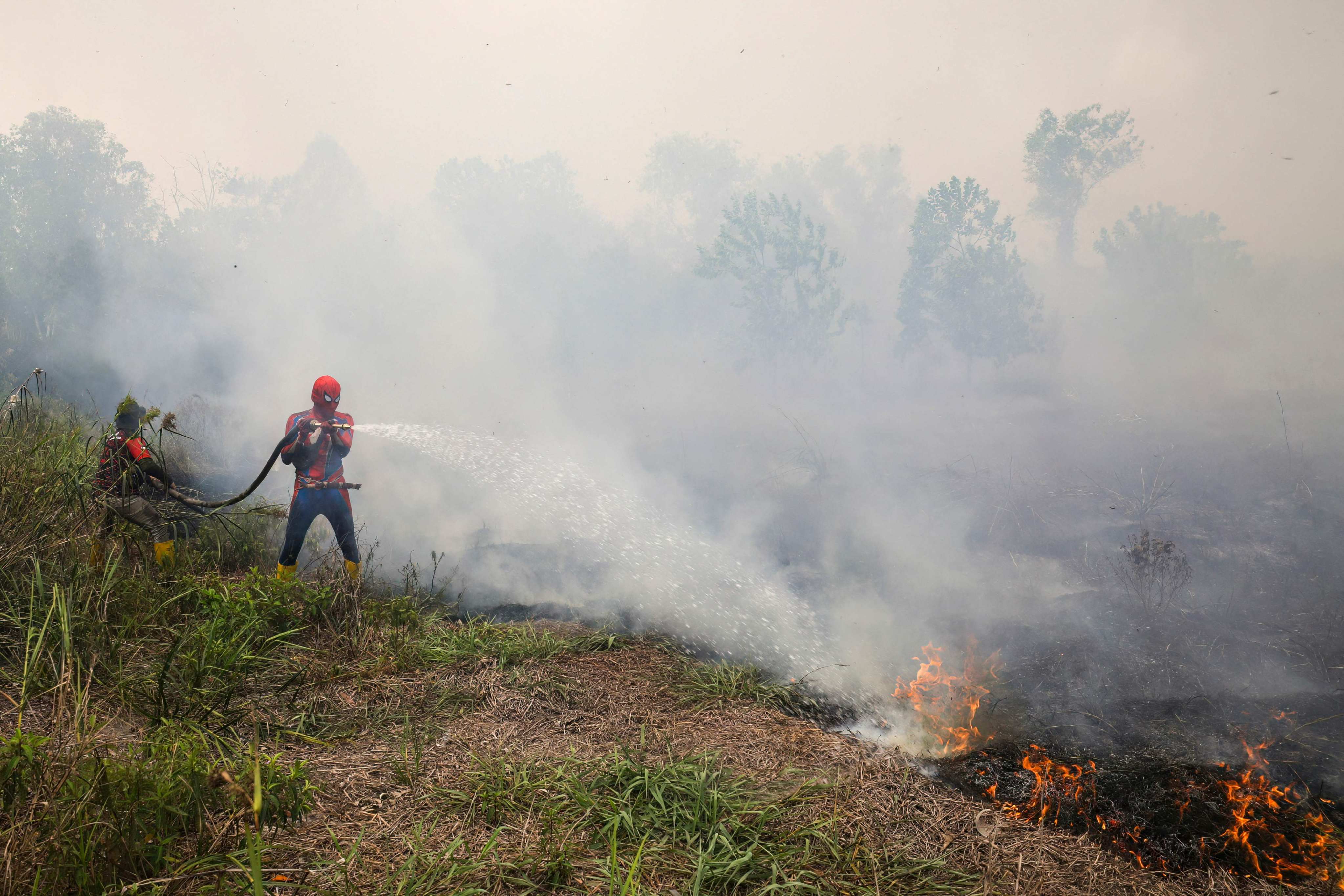 A resident extinguishes a land fire at Kereng Bangkirai in Palangkaraya, Central Kalimantan, on September 9. Photo: AFP