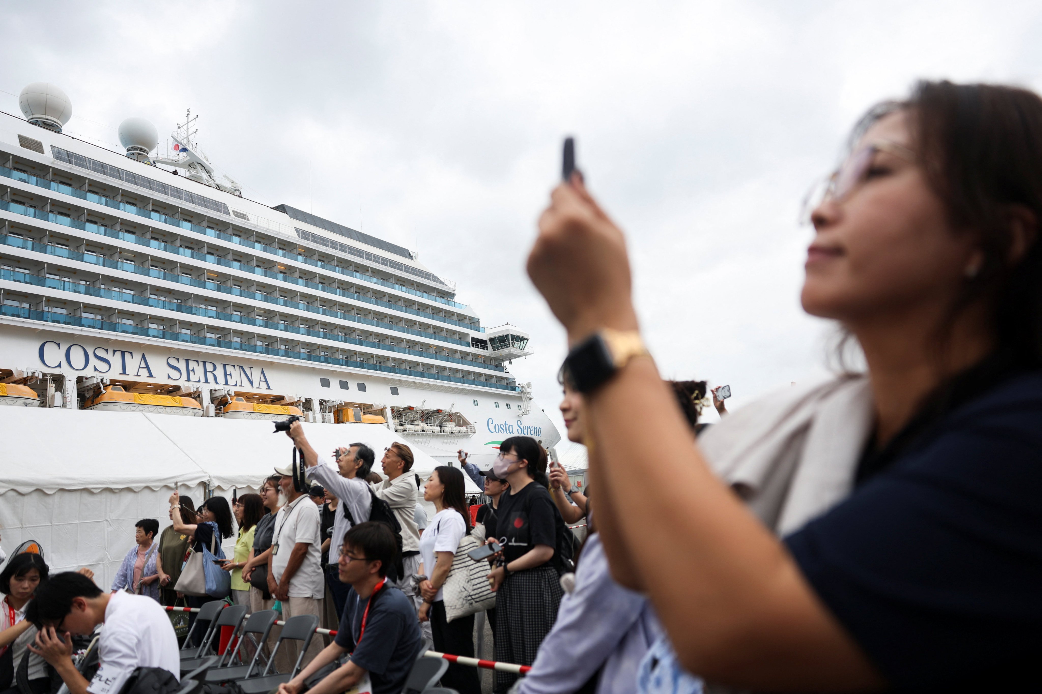 People gather near the Italian cruise ship Costa Serena, which will serve as a floating temporary athletes' village for 4,000 to 5,000 participants during the Aichi-Nagoya 2026 Asian Games, after it docked at the port of Nagoya, Japan, September 15, 2026. REUTERS/Edgar Su