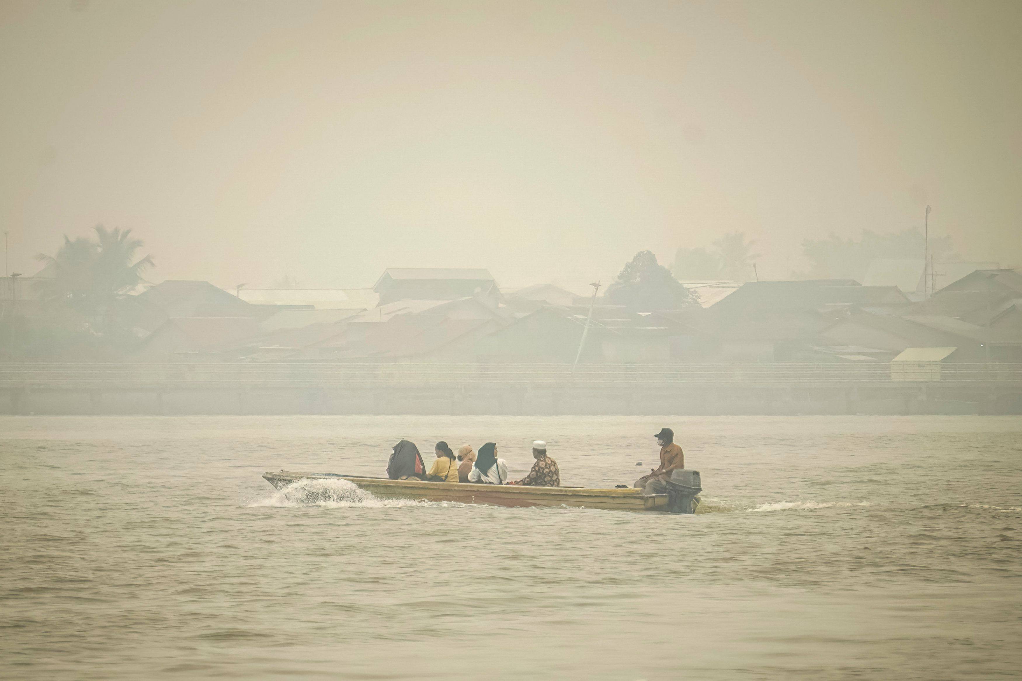 People travel on a river boat as haze from forest fires blankets Benua Melayu Darat village in Pontianak, West Kalimantan, Indonesia, on Wednesday. Photo: AFP