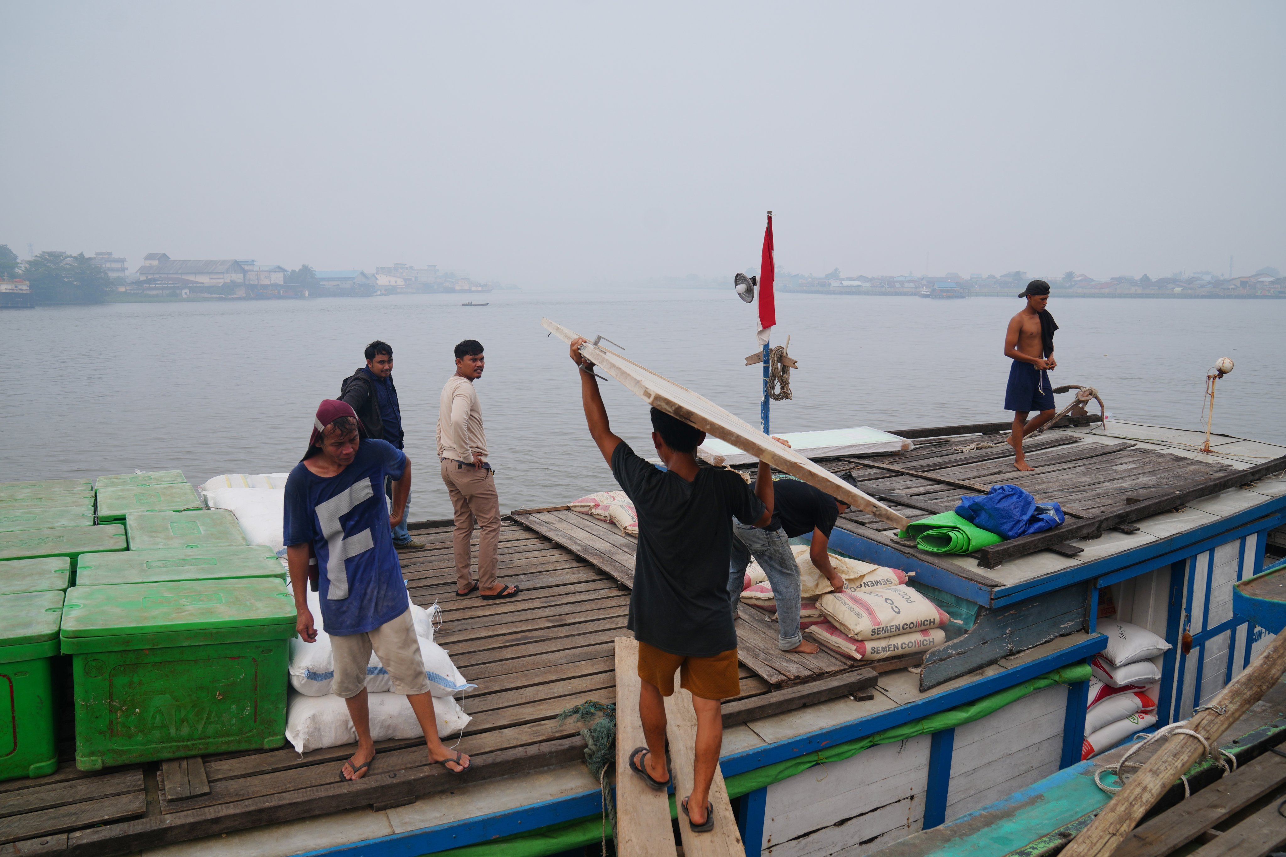 Workers load a boat amid the haze from forest fires at a pier in Pontianak, West Kalimantan, Indonesia, on Monday. Photo: AP