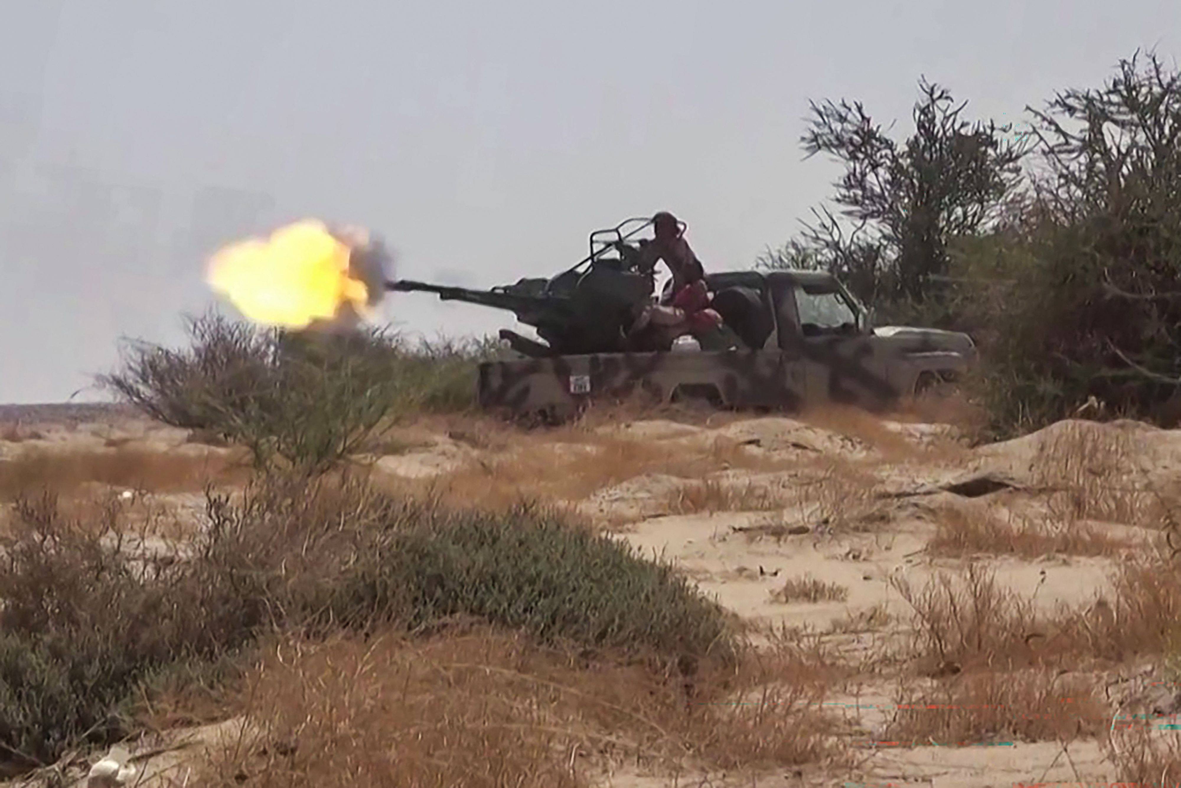 Fighters affiliated with the Saudi-backed Yemeni government engage in clashes with the Houthis in Al-Jawf province on Tuesday. Photo: AFPTV/AFP