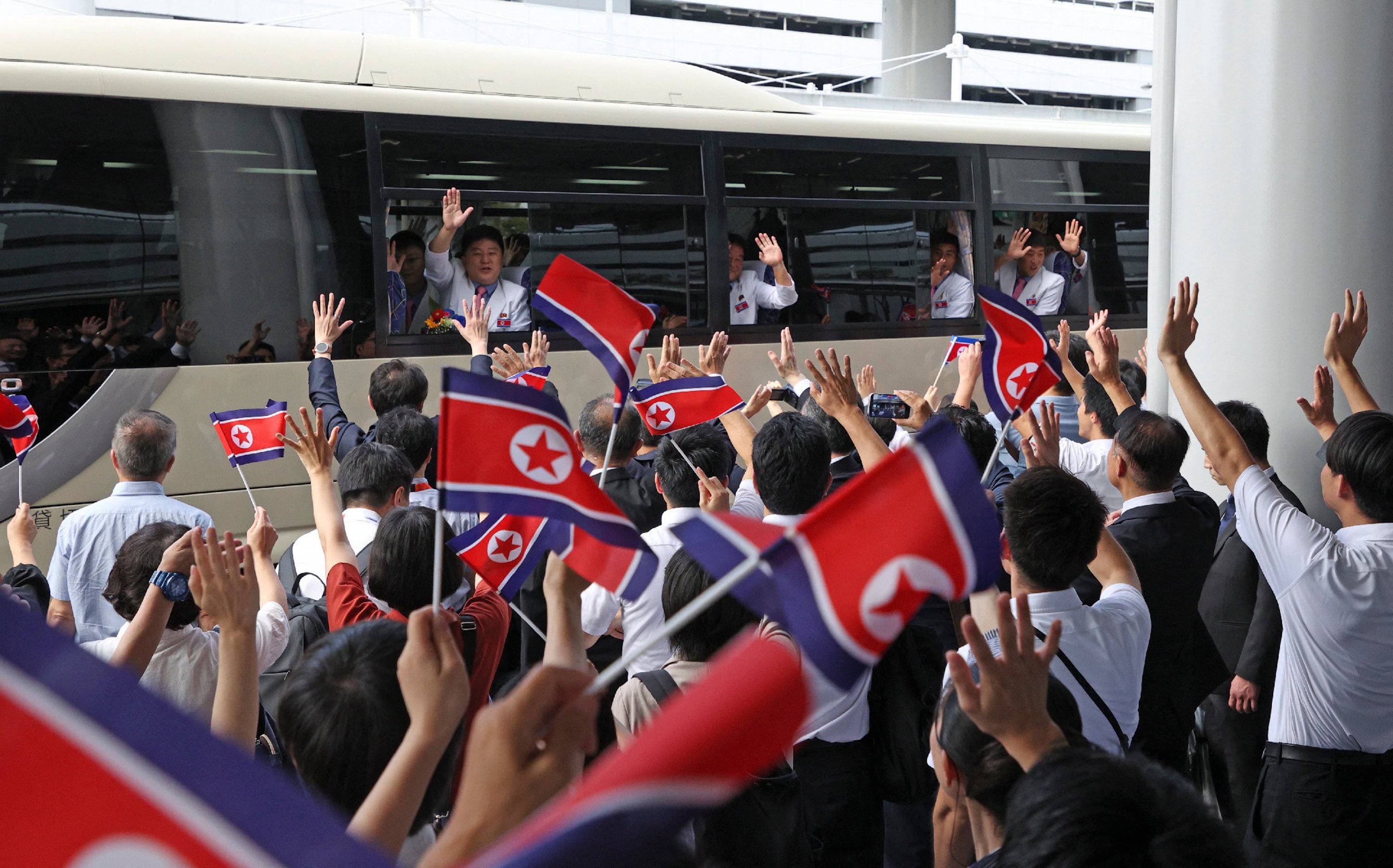 Members of the North Korean men’s football team wave from a bus after arriving at Kansai International Airport for the 2026 Asian Games, in Izumisano, Osaka prefecture, Japan on Friday. Photo: AFP