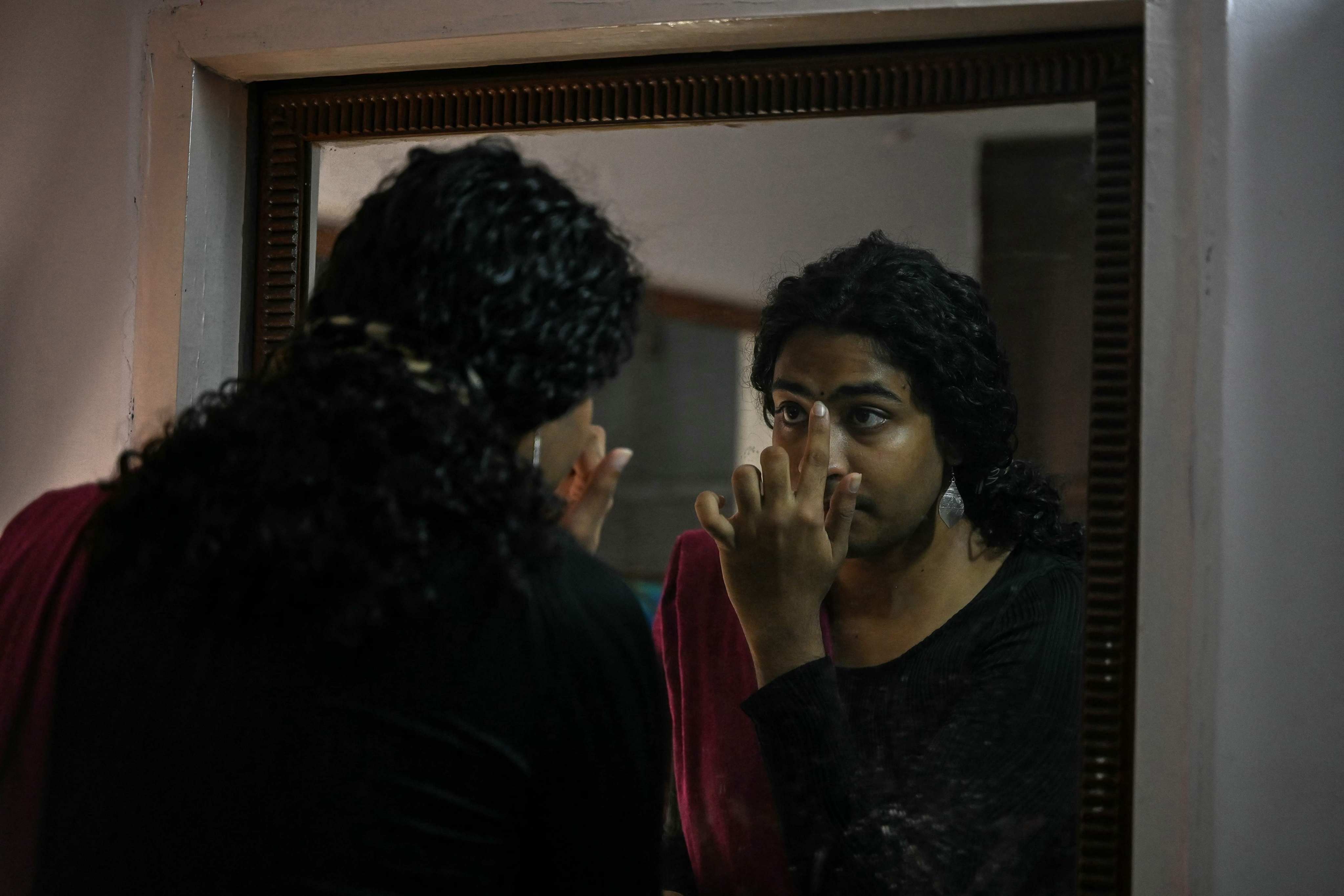 Transgender woman Kali Sidharth Medepalli checks herself in the mirror in Hyderabad on August 26. Photo: AFP