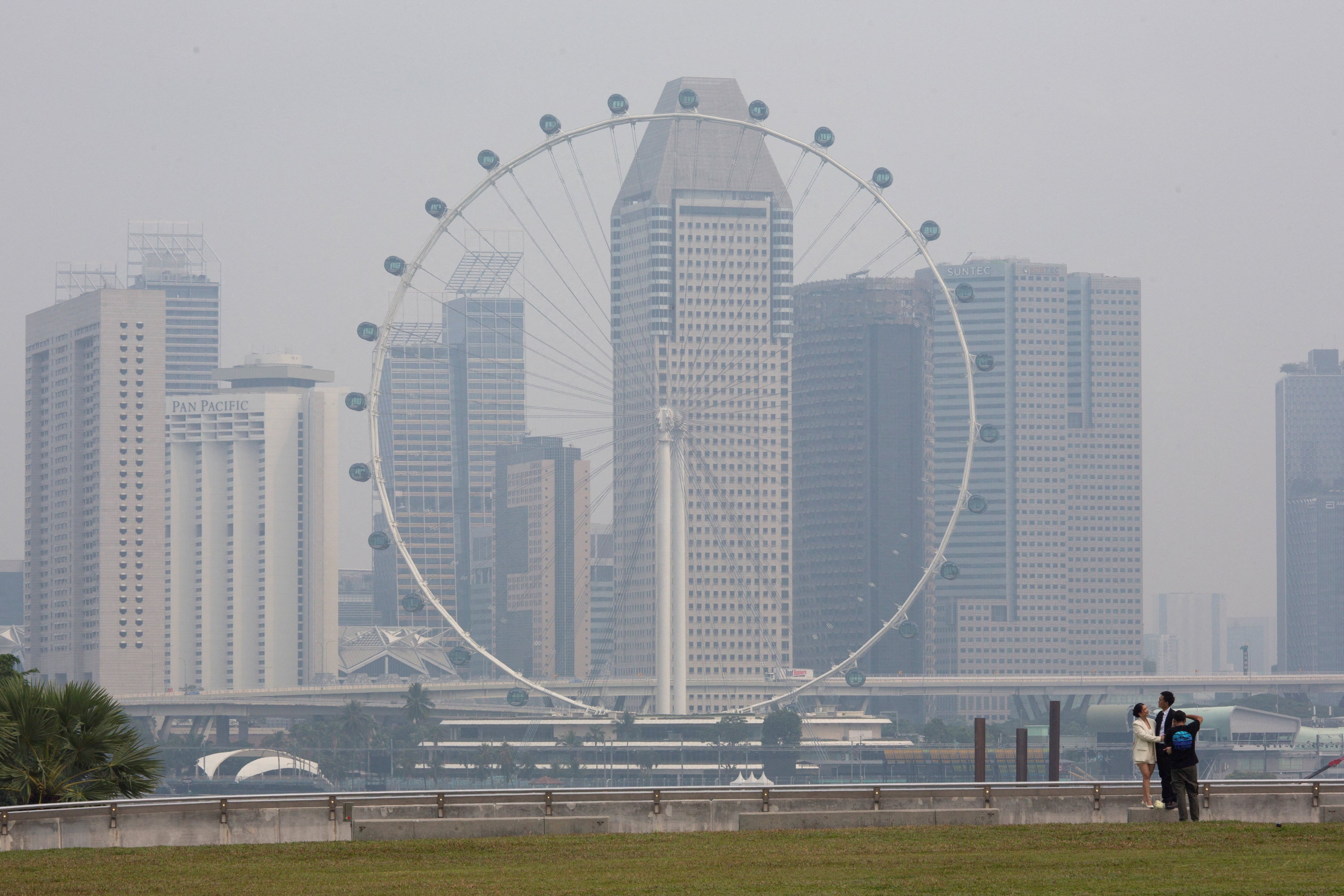 The Singapore Flyer and commercial buildings are shrouded in haze at the Marina Bay area in Singapore on Tuesday. Photo: Reuters