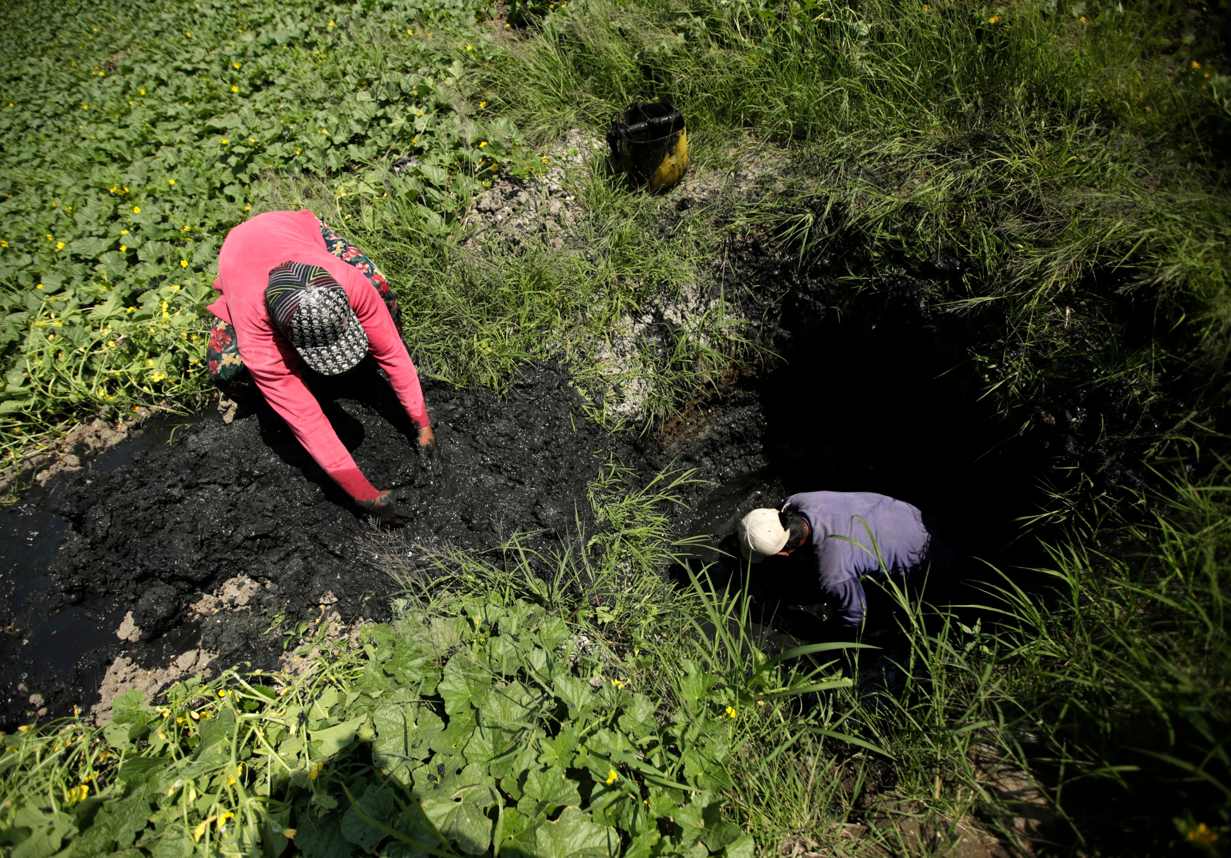 Filipino farmers dig a hole in the ground to find water for their crop at a field in Taguig City in March 2019. Photo: EPA-EFE