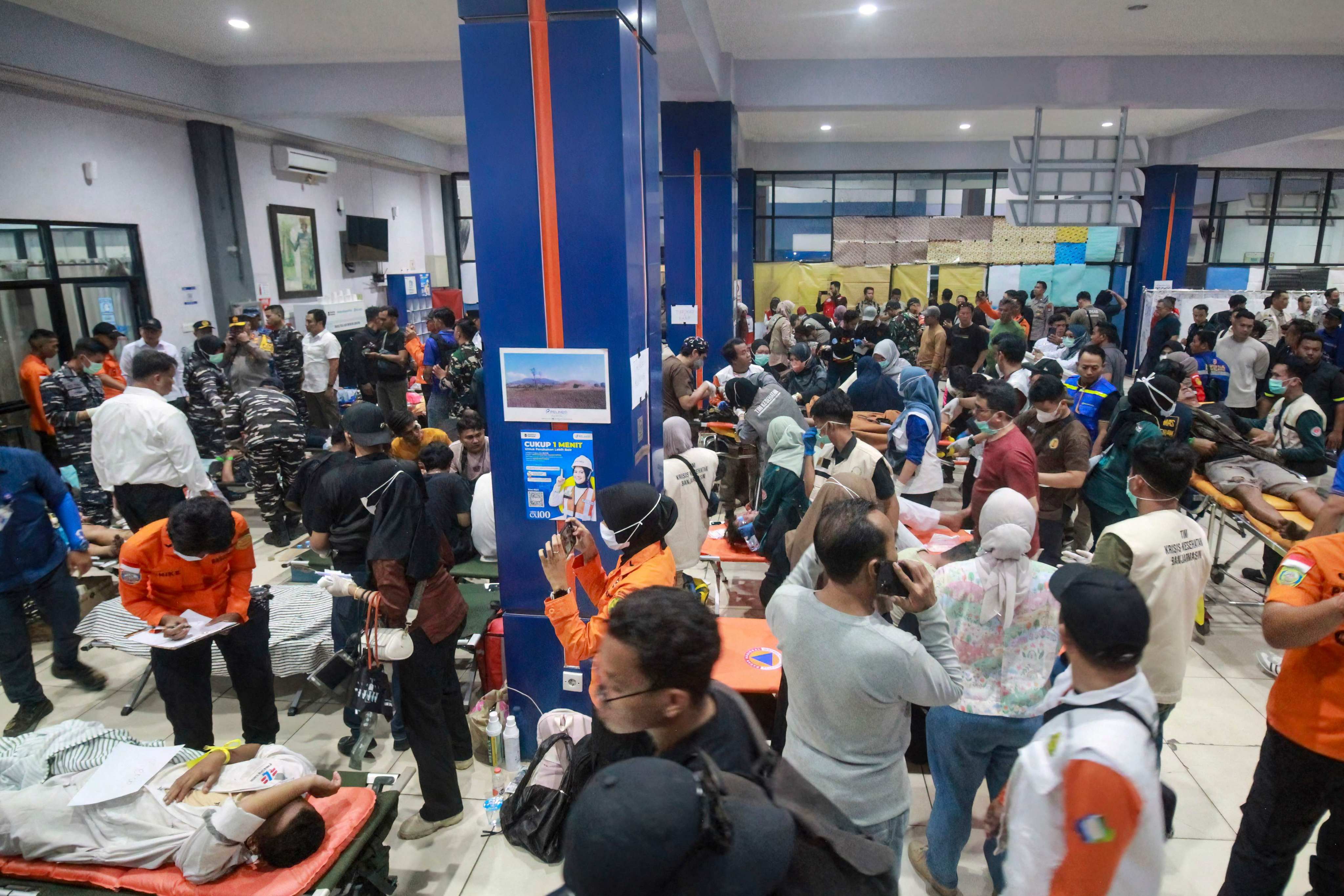 Rescue teams prepare to evacuate victims of the Virgo Transport 8 passenger ferry at the port hall before heading to a hospital in Banjarmasin, South Kalimantan on Sunday. Photo: AFP