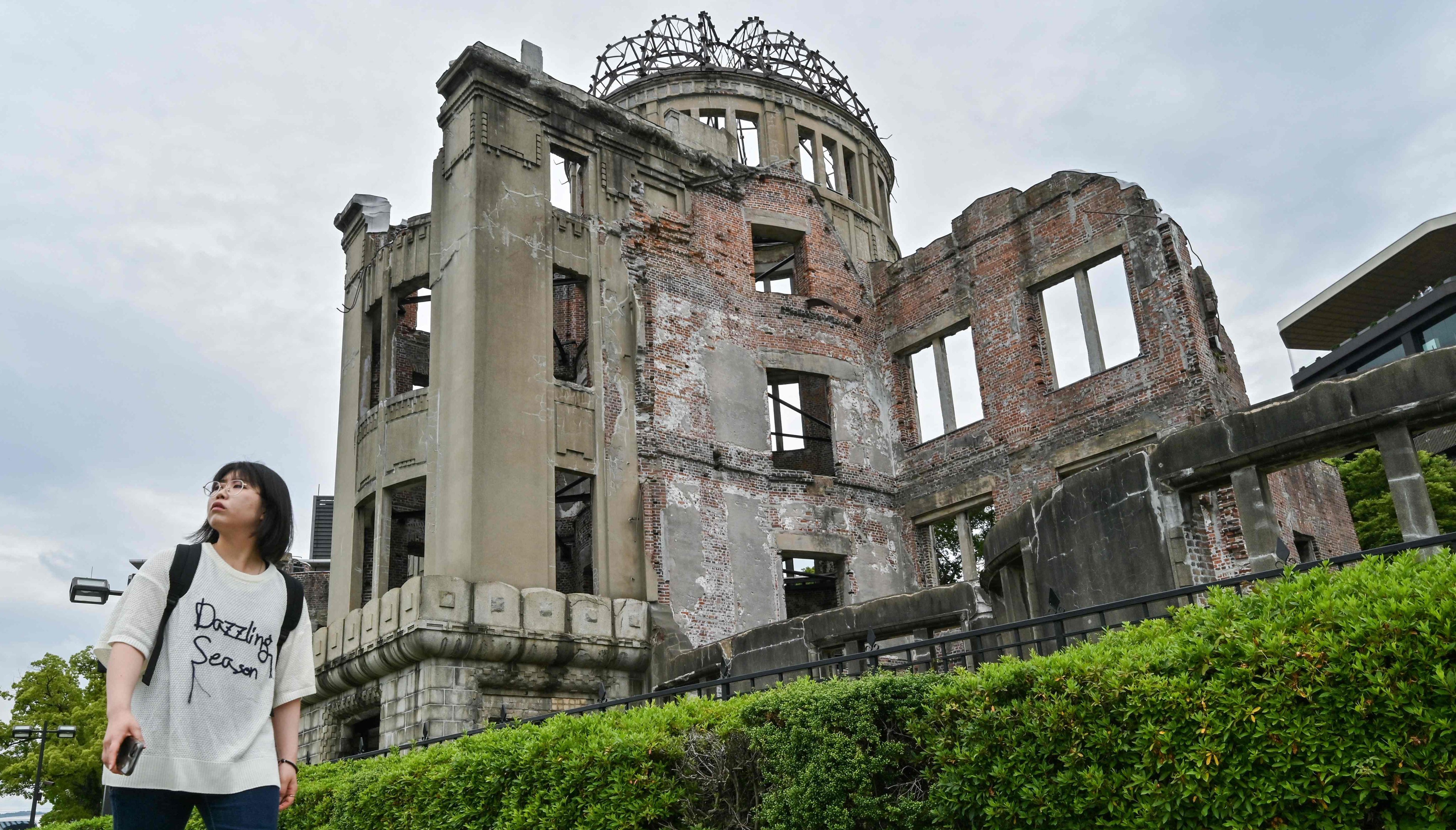 A woman walks past the Atomic Bomb Dome in the centre of Hiroshima in 2025, ahead of the 80th anniversary of the bombing of Hiroshima and Nagasaki. Photo: AFP