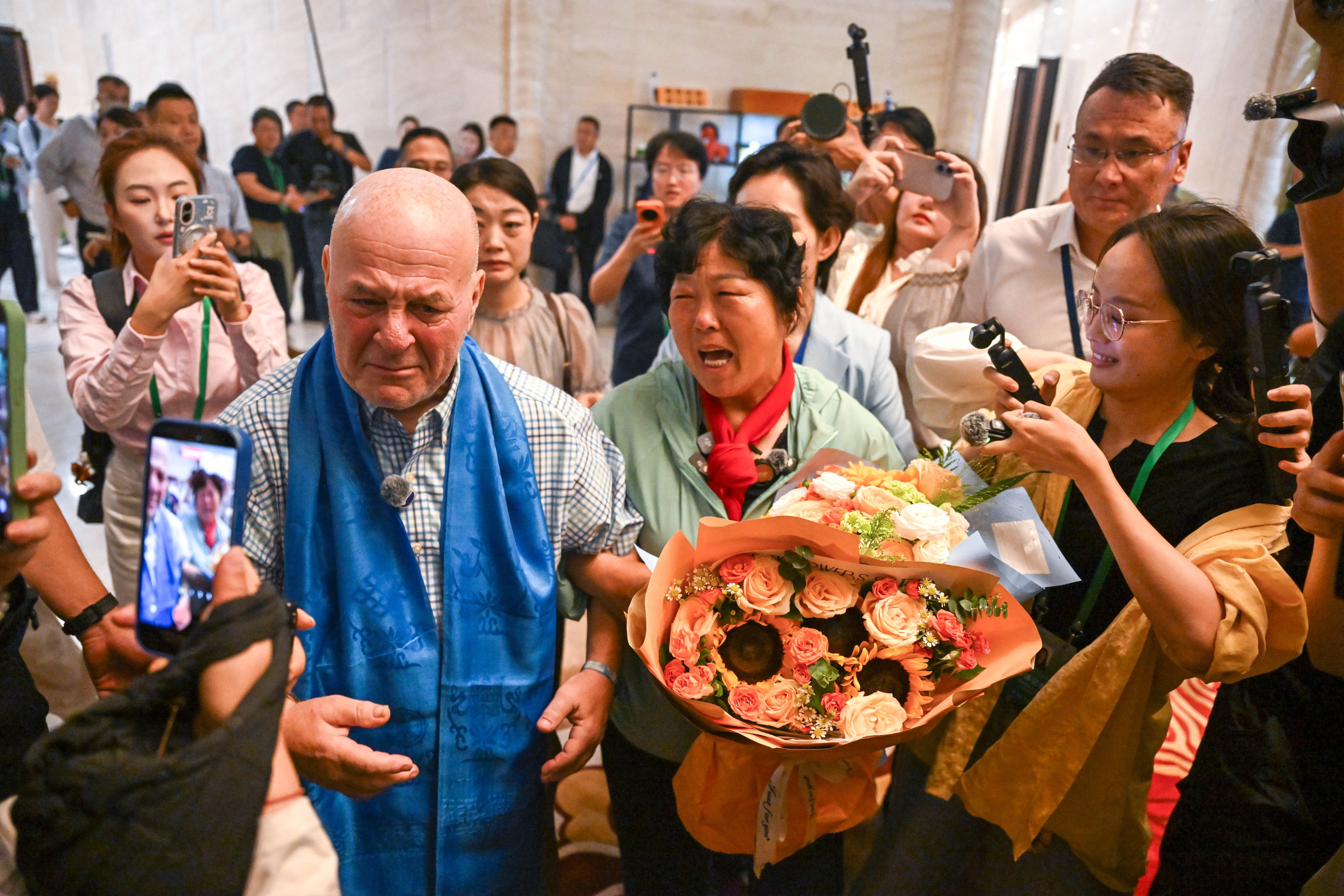 Yin Yuzhen, now a ‘national model worker’, and retired American teacher Ronald Sakolsky at an airport in Ordos in China’s Inner Mongolia autonomous region, on August 23. Photo: Xinhua