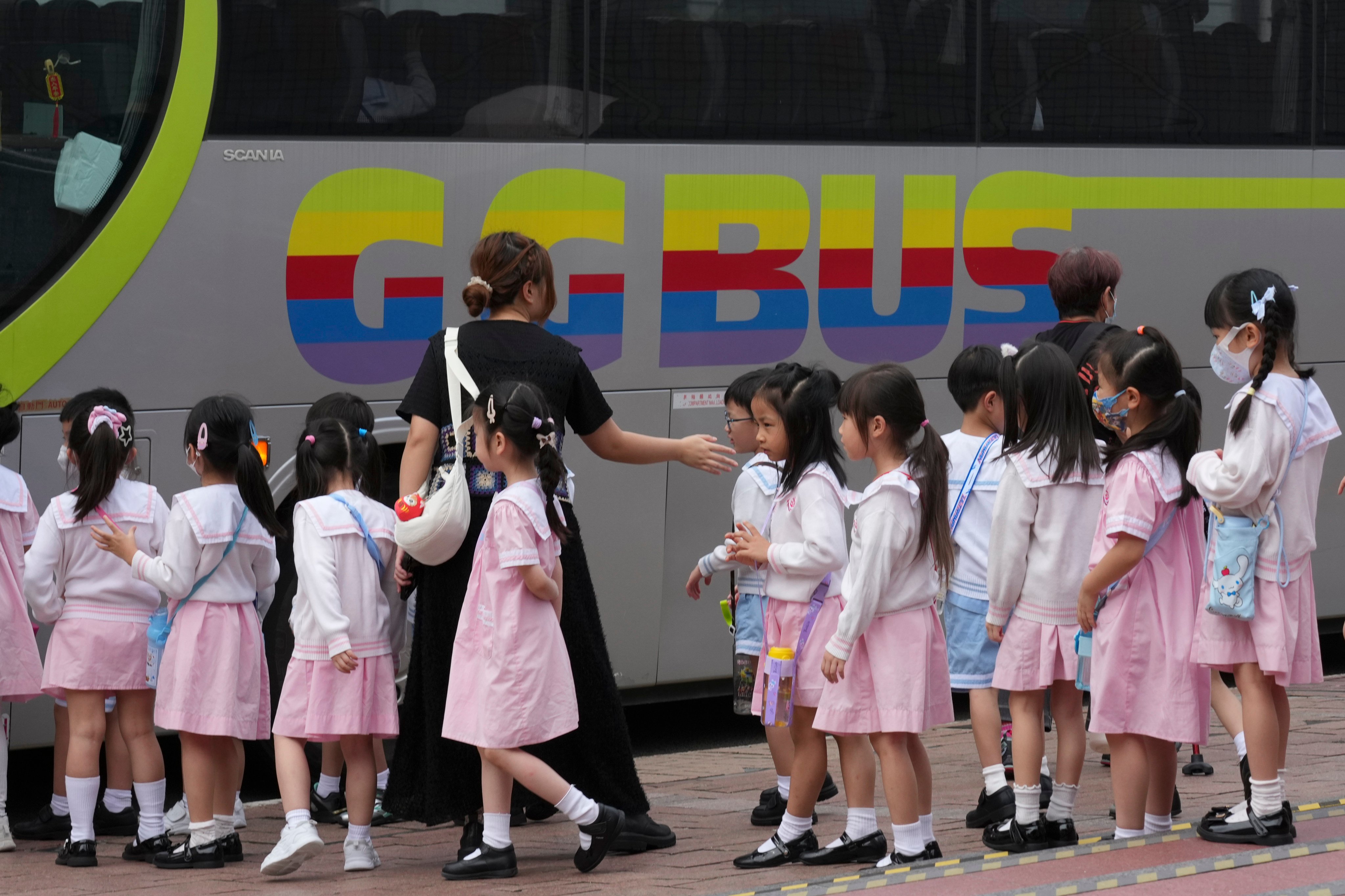 A group of kindergarten students queue up to board a bus for a school field trip, guided by their teacher, outside the Hong Kong Space Museum in Tsim Sha Tsui on May 19. Photo: Jelly Tse