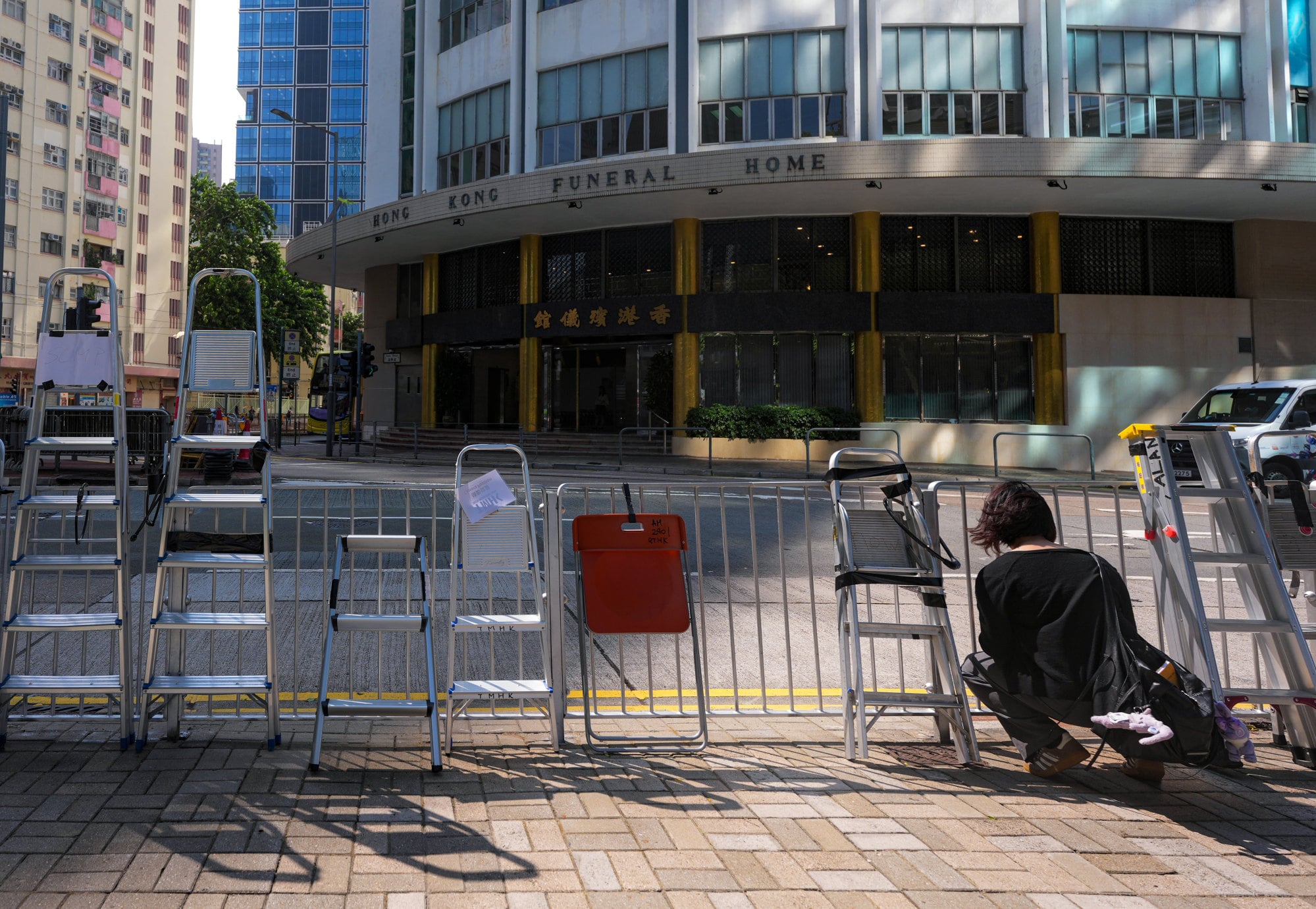 Ladders set up by media outlets line metal barricades across from the Hong Kong Funeral Home in North Point. Photo: Karma Lo Ladders set up by media outlets line metal barricades across from the Hong Kong Funeral Home in North Point. Photo: Karma Lo