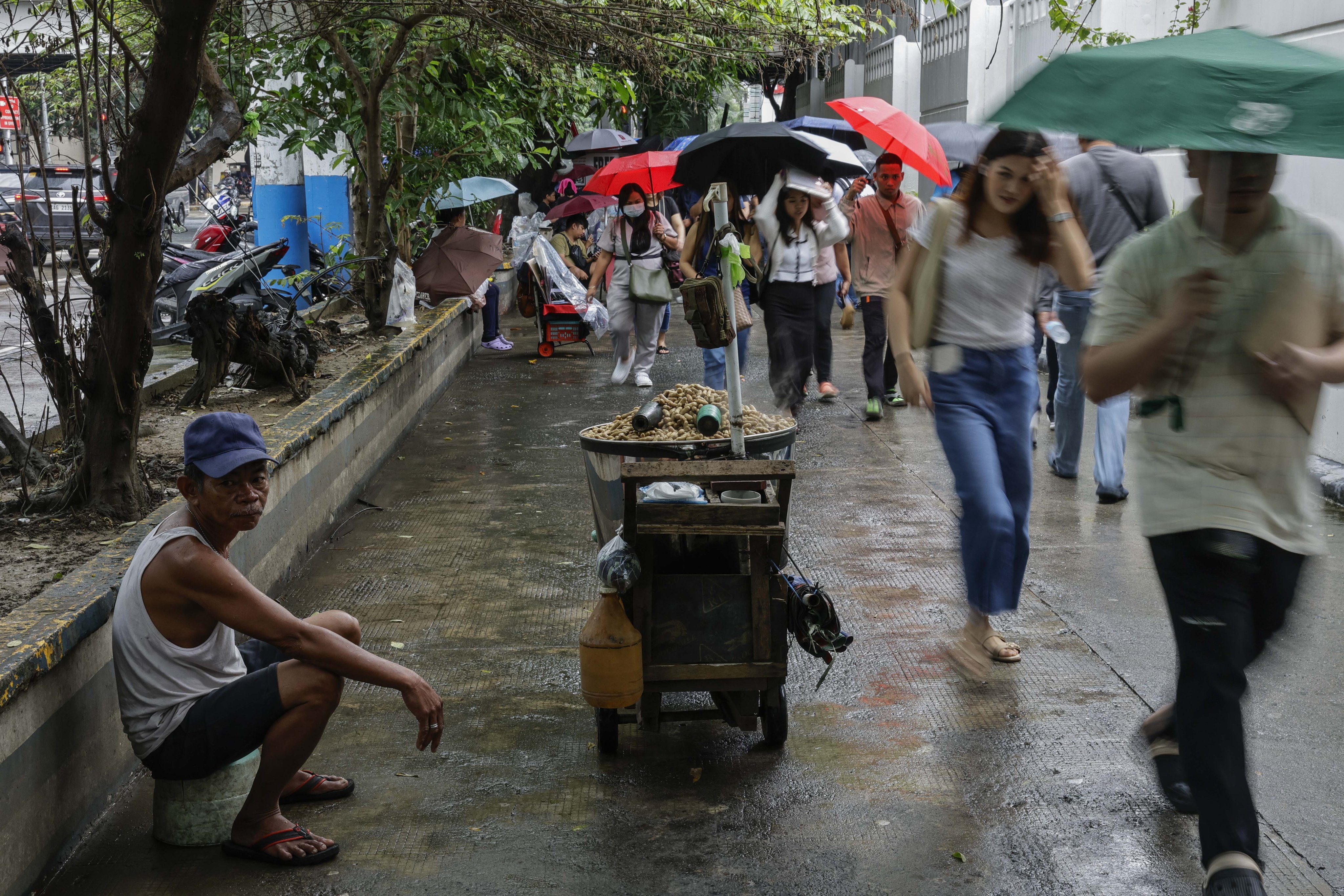 People walk past a peanut vendor in Manila, the Philippines, on September 8. Photo: EPA