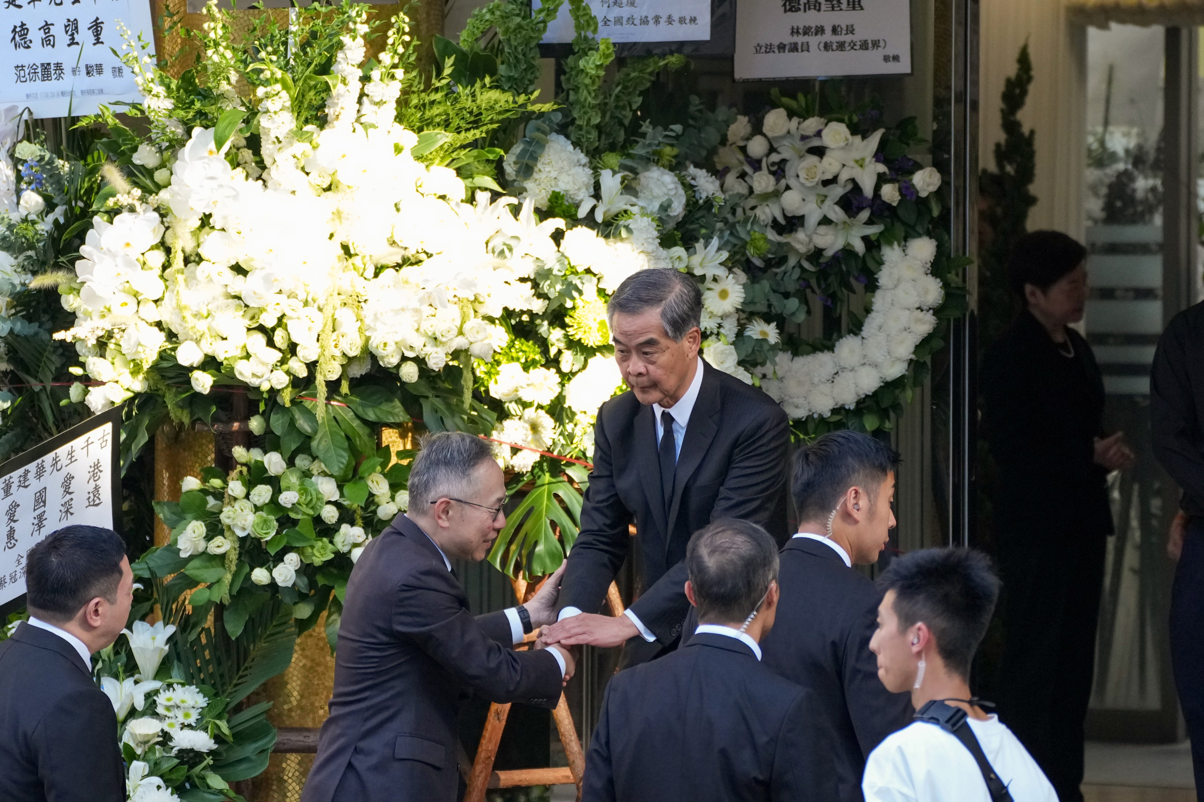 Former chief executive Leung Chun-ying (centre) arrives at the funeral hall. Photo: Kit Lai