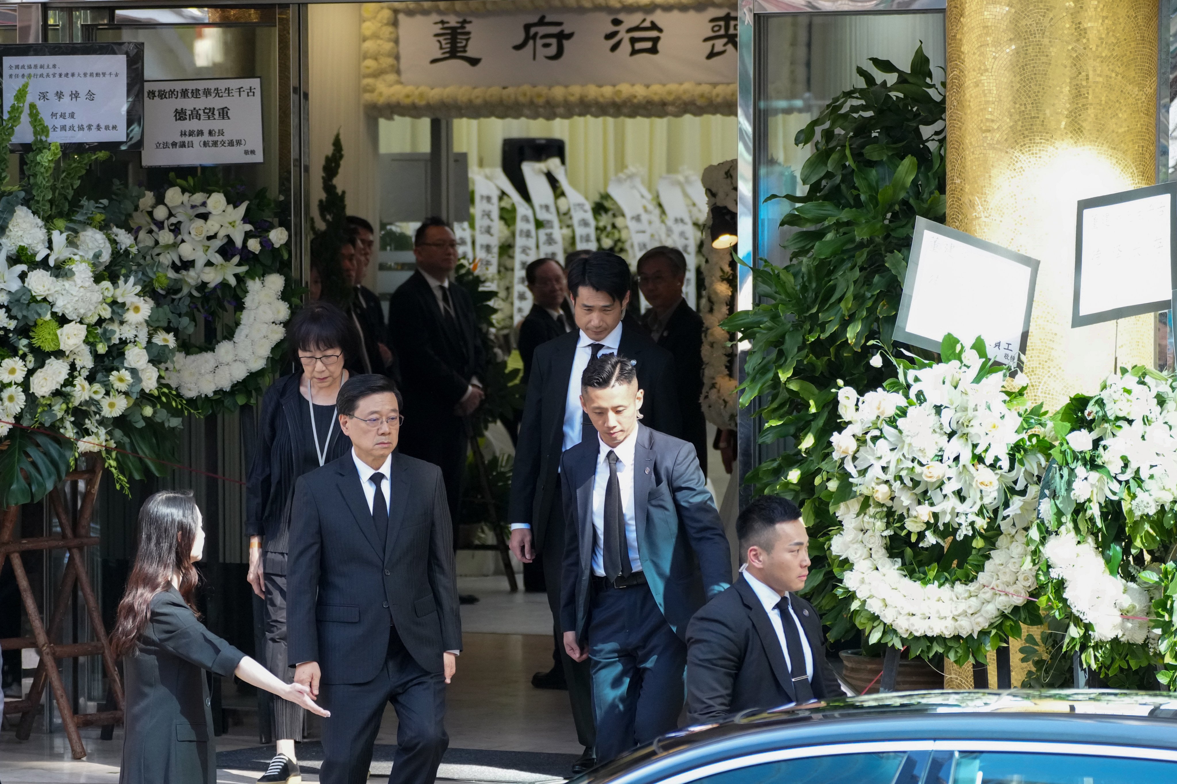 Chief Executive John Lee (left) leaves the funeral parlour. Photo: Kit Lai