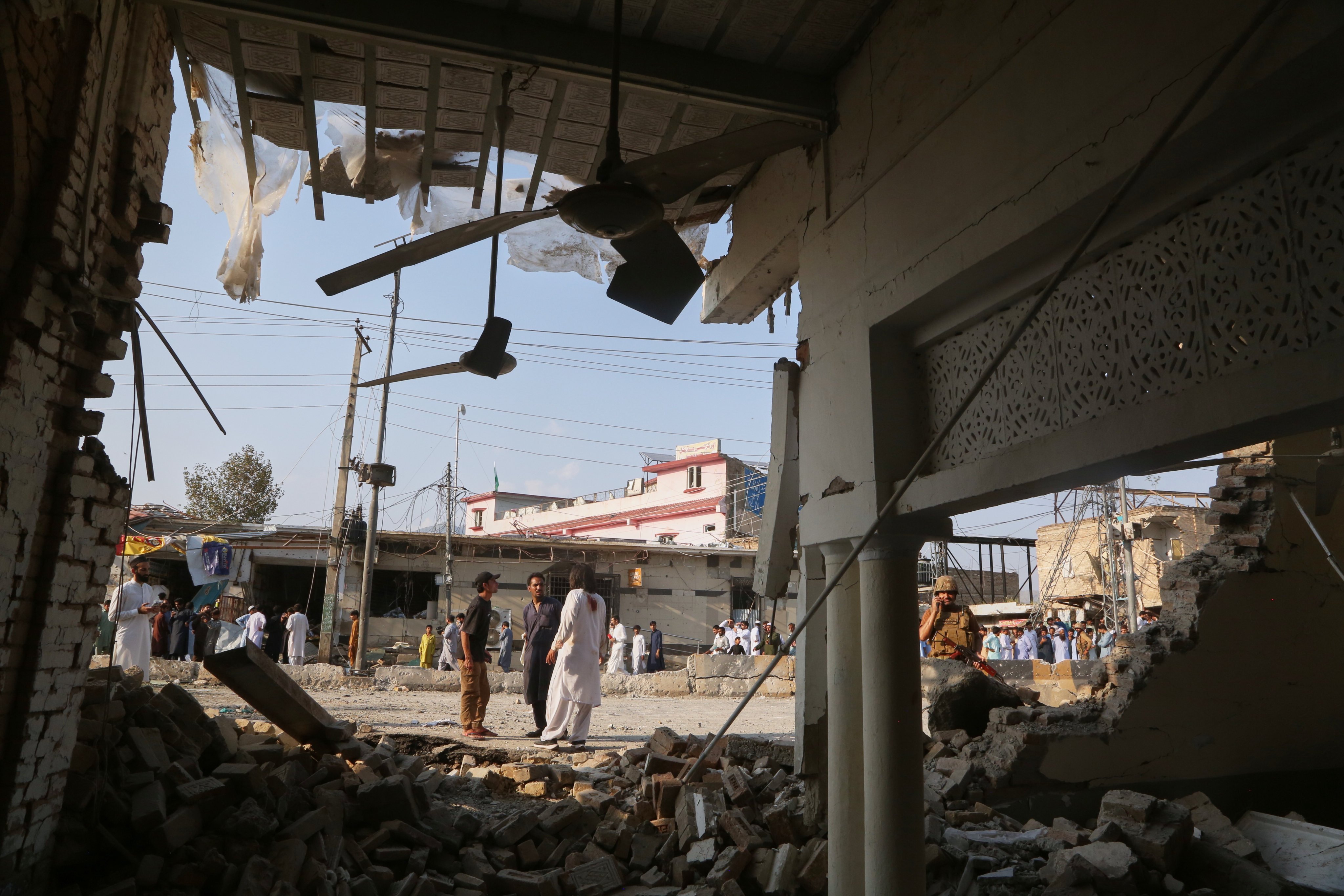 An army soldier and local residents look at a damaged portion of a mosque after a bomb exploded in Kohat on Friday. Photo: AP