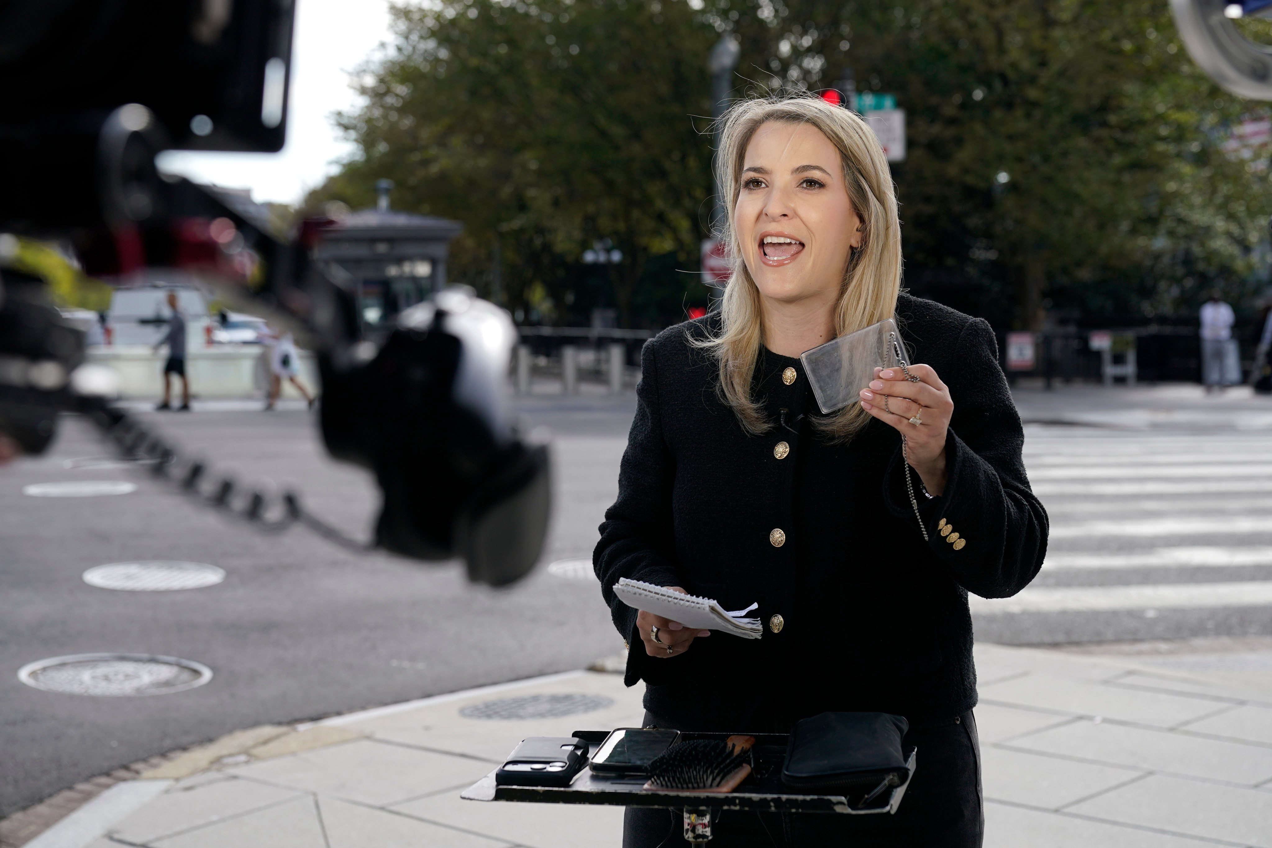 CNN Senior White House Reporter Betsy Klein, holding up an empty credential holder, reports near the White House complex on Saturday. Photo: AP