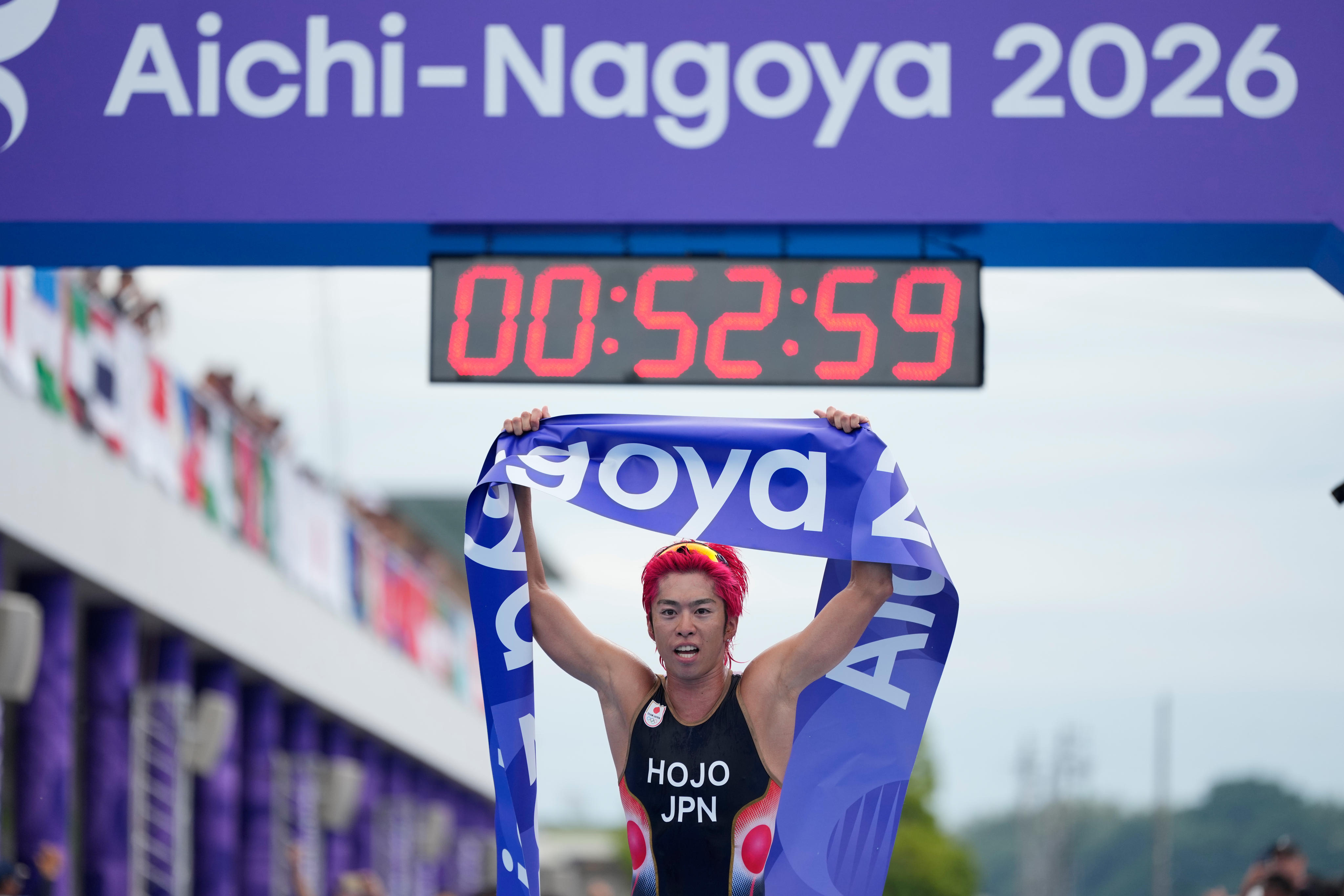 Takumi Hojo celebrates winning the men’s triathlon in his home Asian Games. Photo: AP