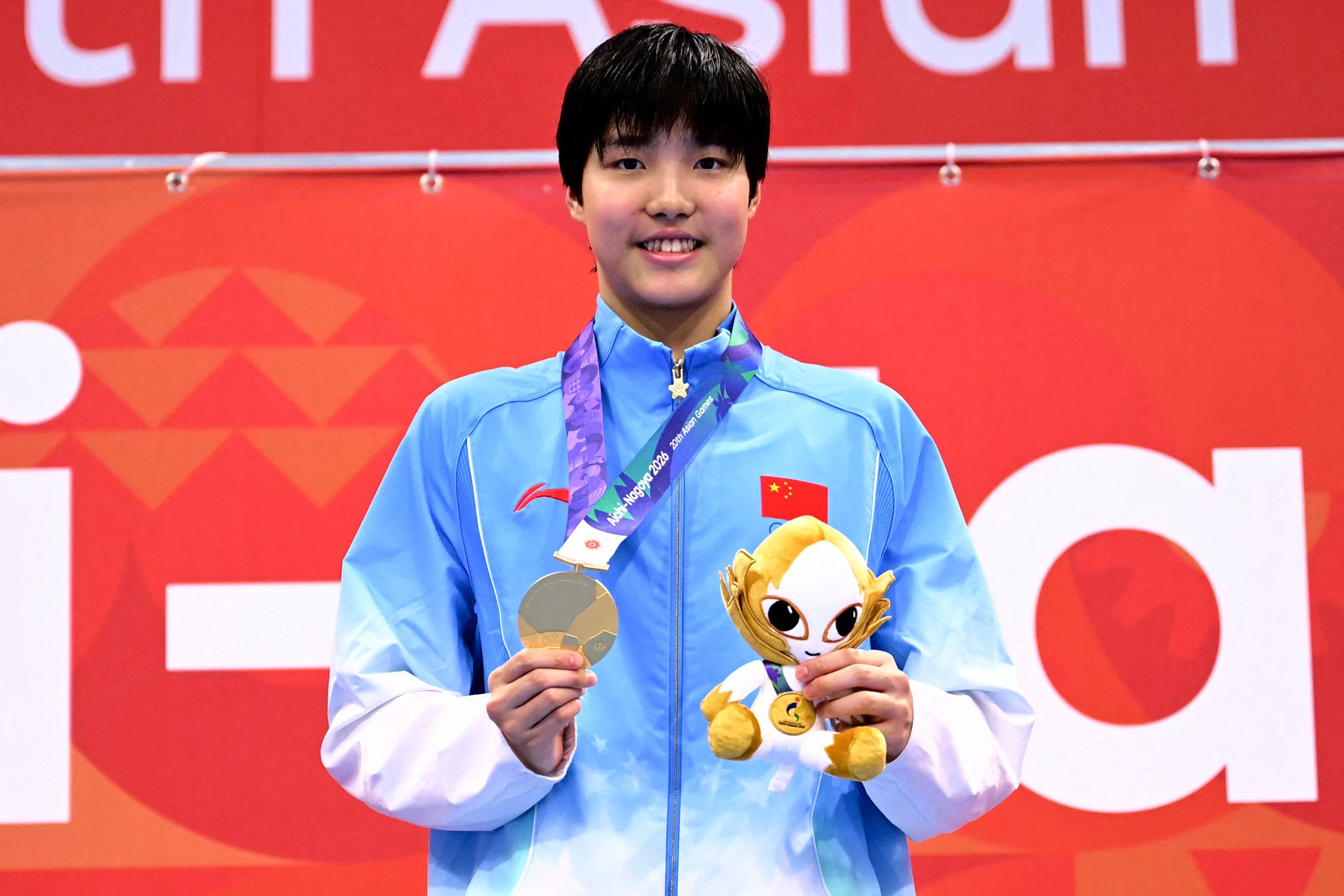 Gold medallist Yu Zidi celebrates on the podium after her dominant victory. Photo: AFP