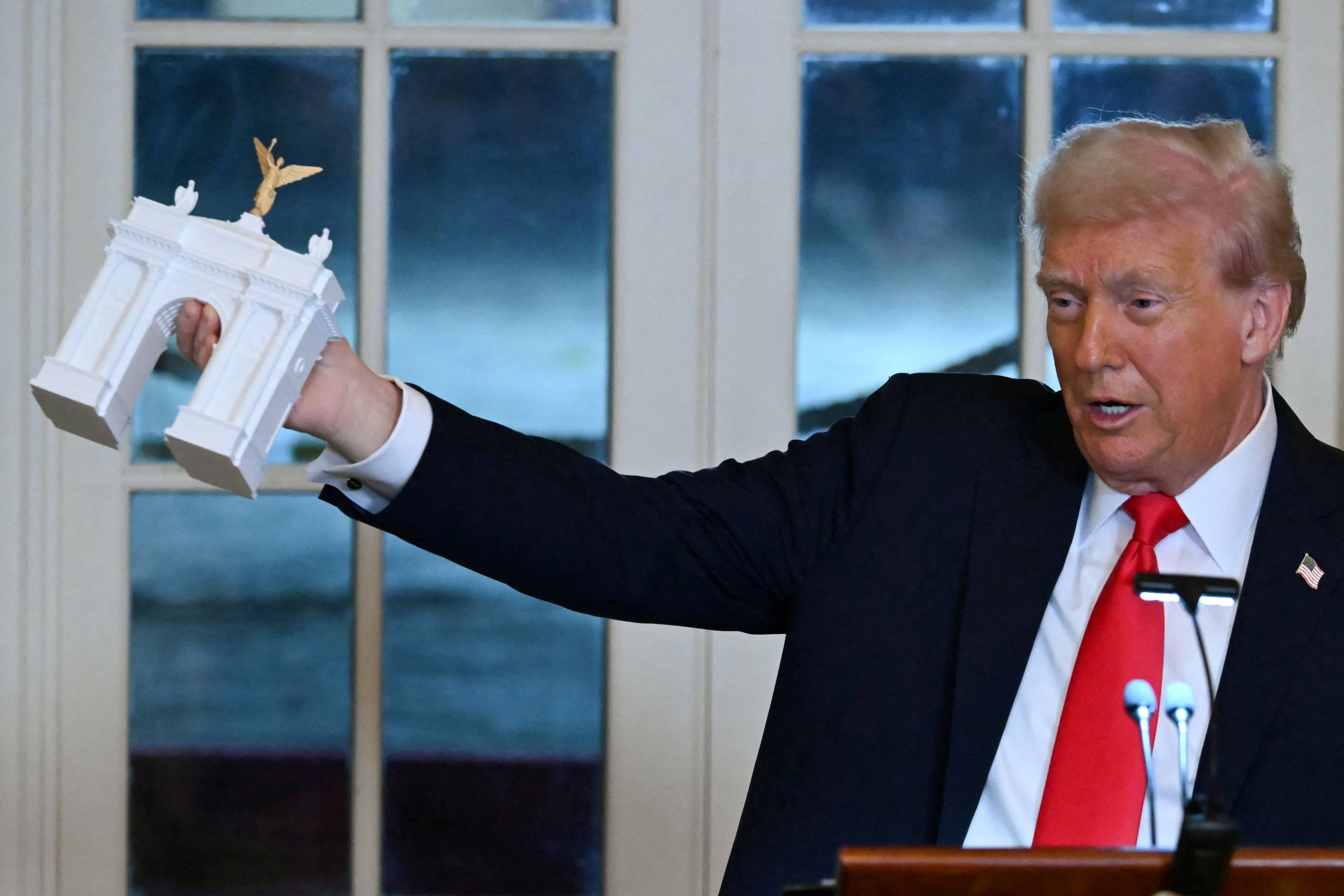 US President Donald Trump holds up a model for a proposed ‘Independence Arch’ during a dinner with ballroom donors in the East Room of the White House in Washington on October 15 last year. Photo: AFP