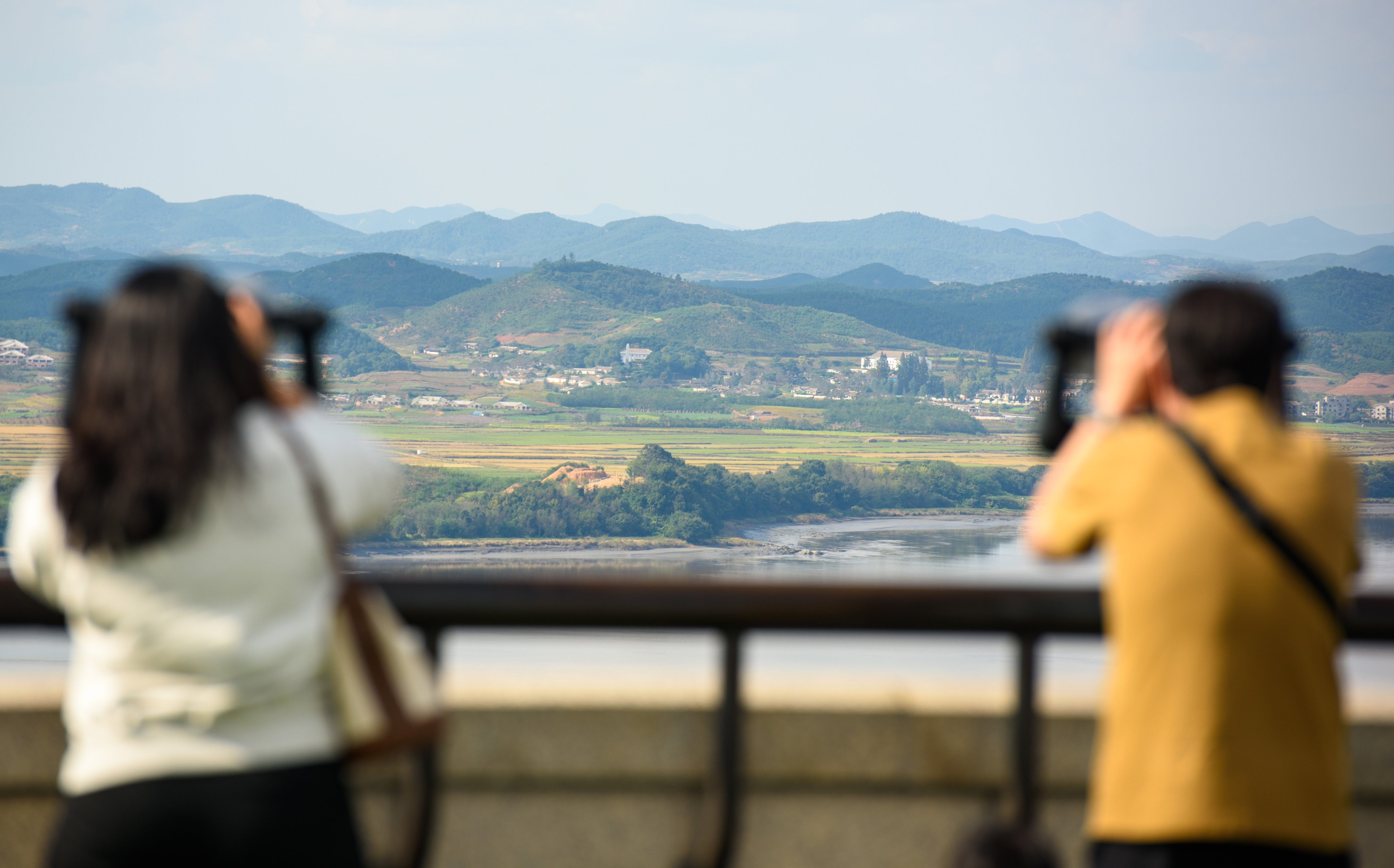 Visitors use binoculars to look at the North Korean side of the demilitarised zone dividing the two Koreas. Photo: Sopa Images/LightRocket/Getty Images