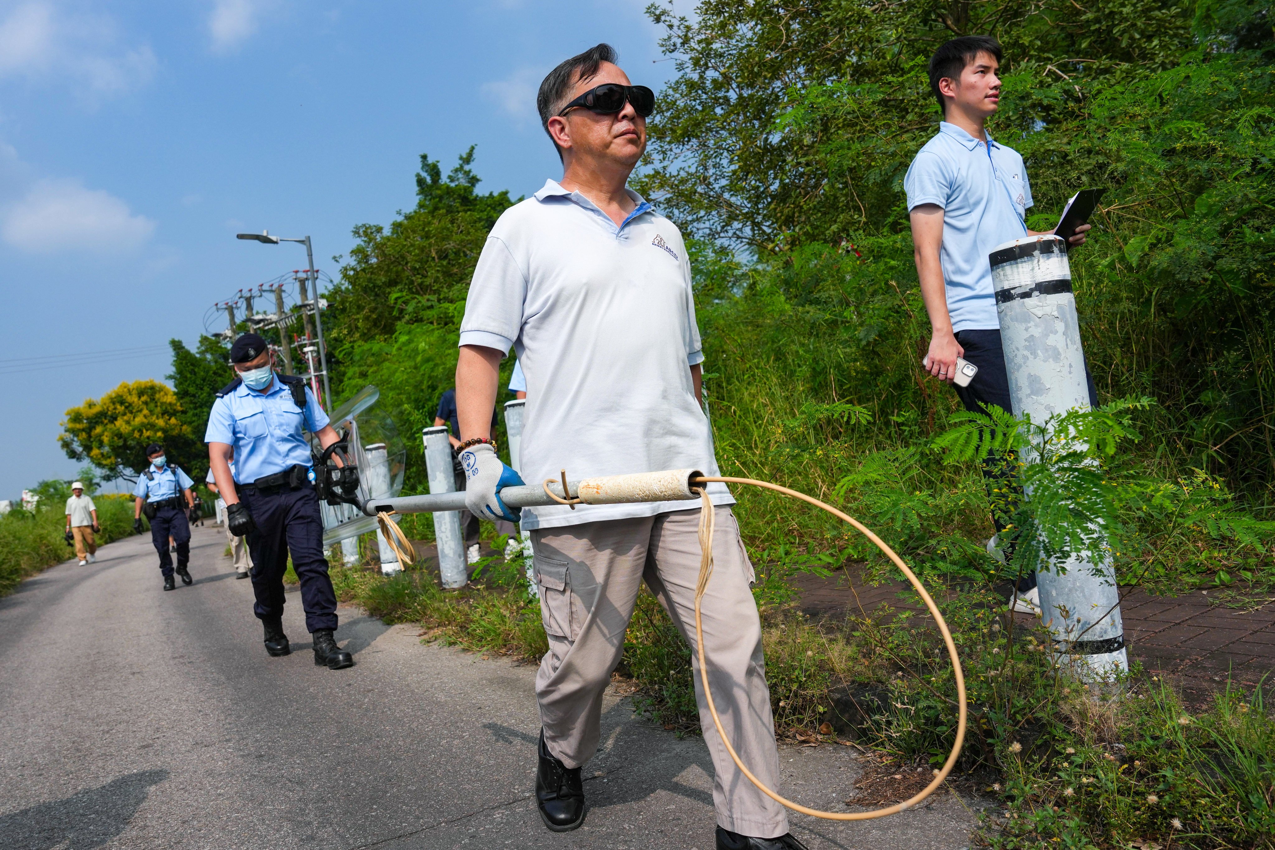 Police and AFCD officers search for strays in Pok Wai, Yuen Long, where a 27-year-old female cyclist was found dead in a suspected dog attack on Sunday. Photo: Kit Lai