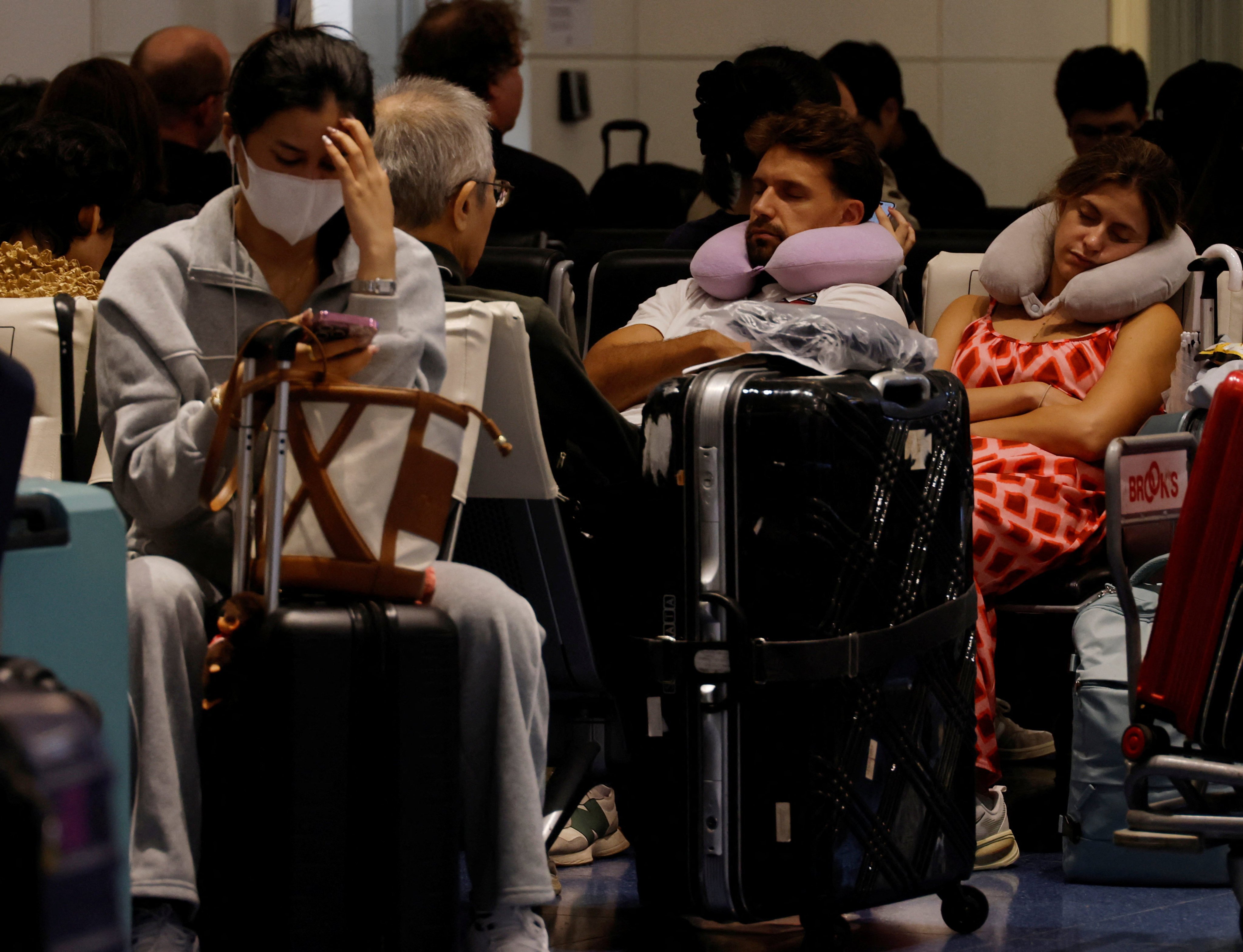 Passengers rest at Haneda airport in Tokyo on Monday. Photo: Reuters