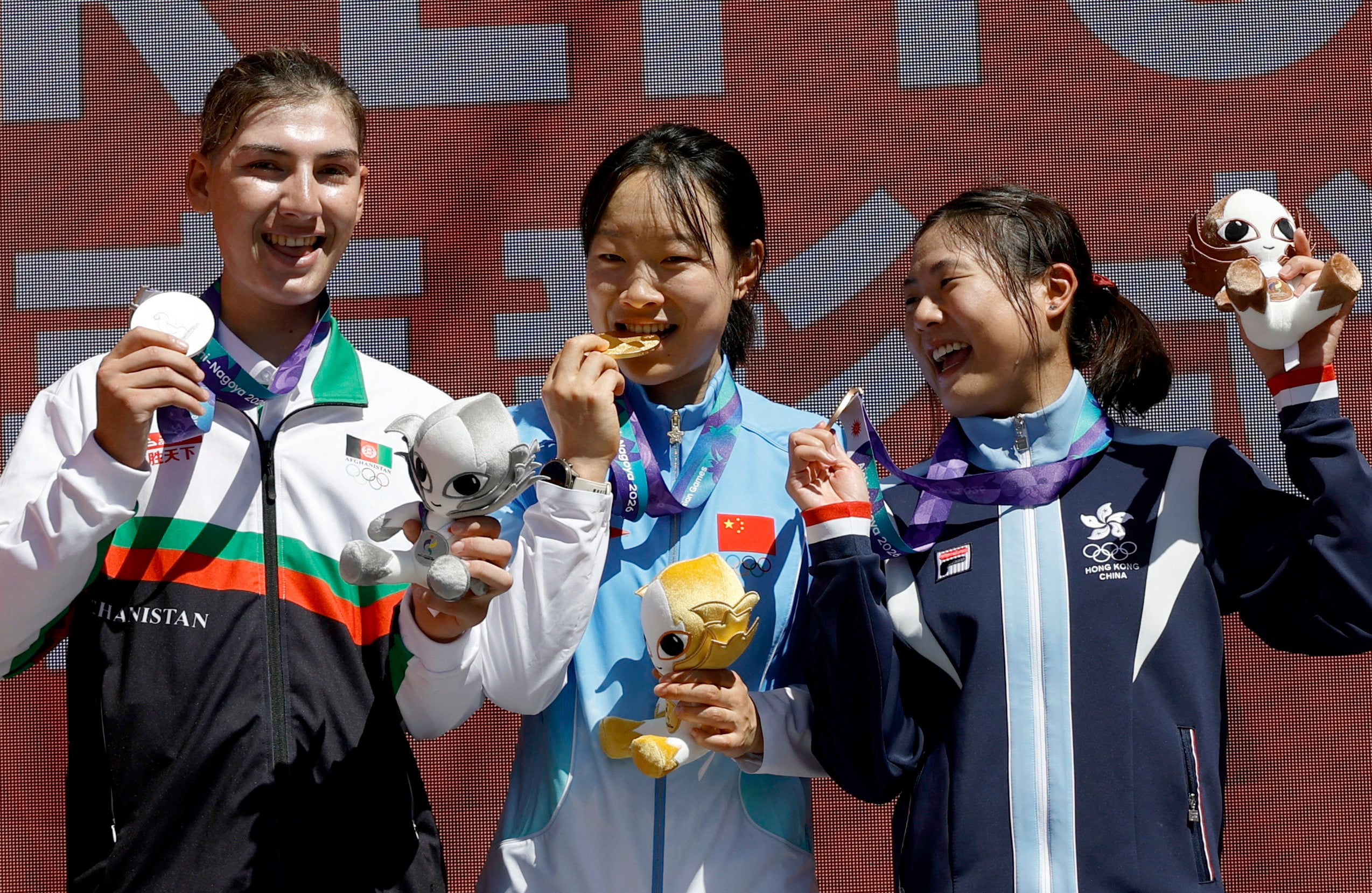 Chloe Leung (right) celebrates her Asian Games road race bronze. Photo: Reuters