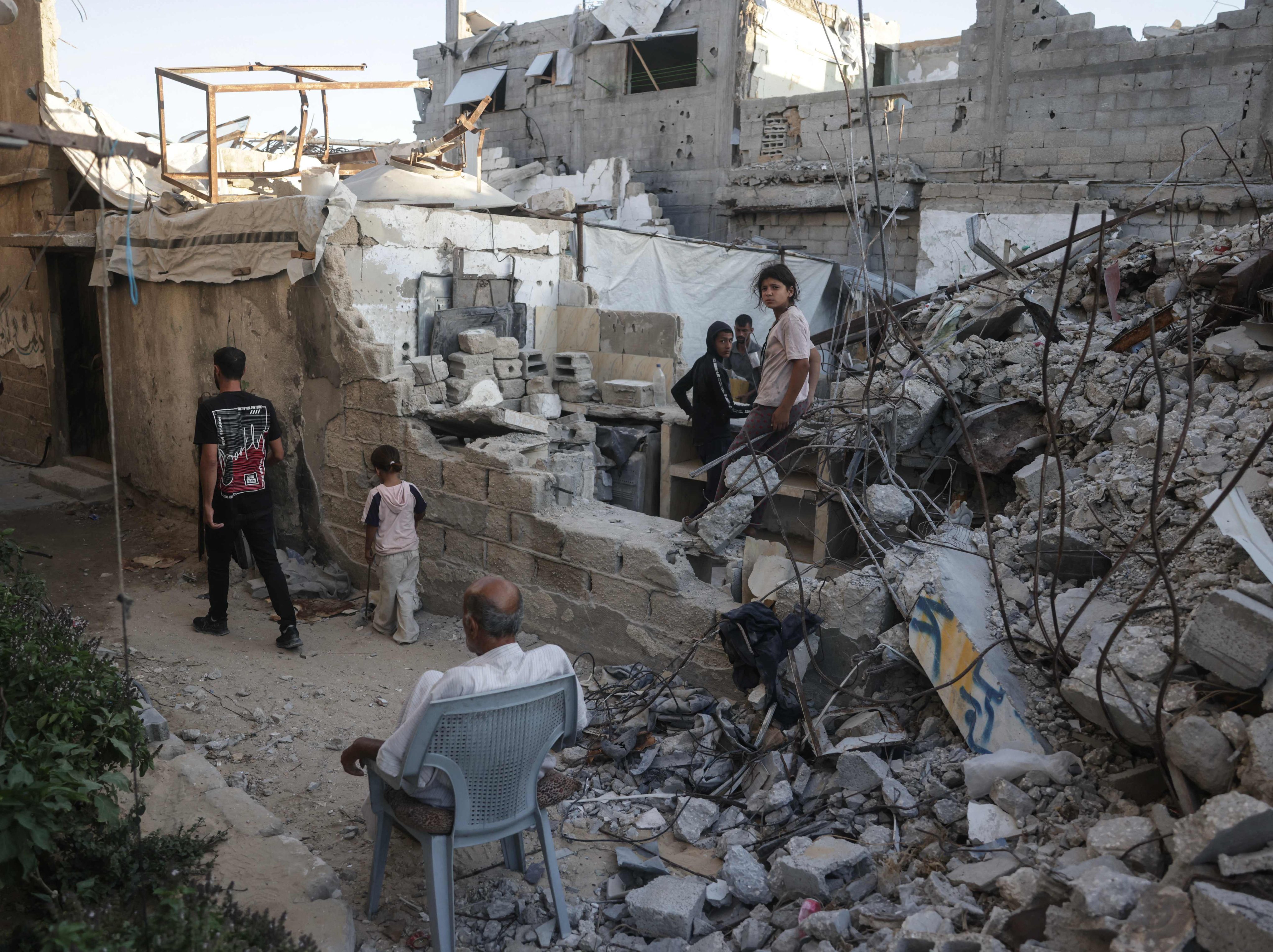 Displaced Palestinians gather on Saturday amid the rubble of a building being used as a shelter in Khan Yunis in the southern Gaza Strip. Photo: AFP