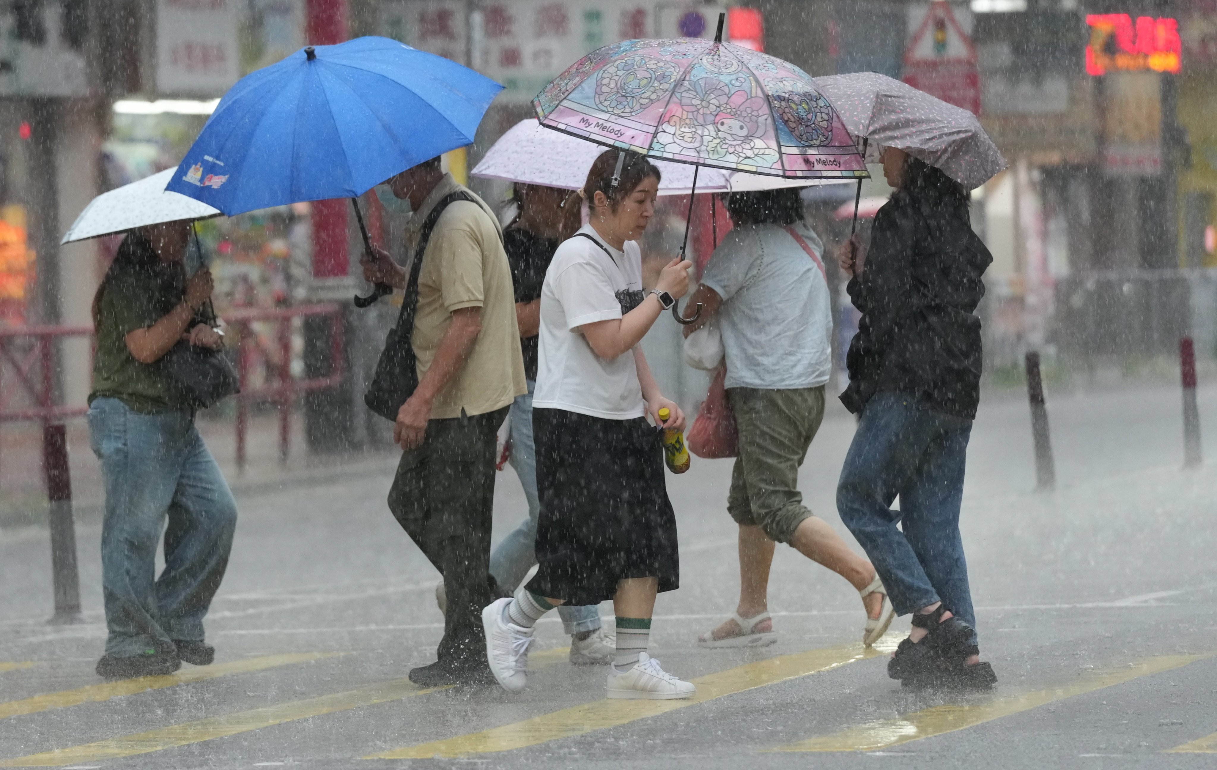 Pedestrians holding umbrellas make their way across a street in Tai Po during a downpour on July 17. Photo: Jelly Tse
