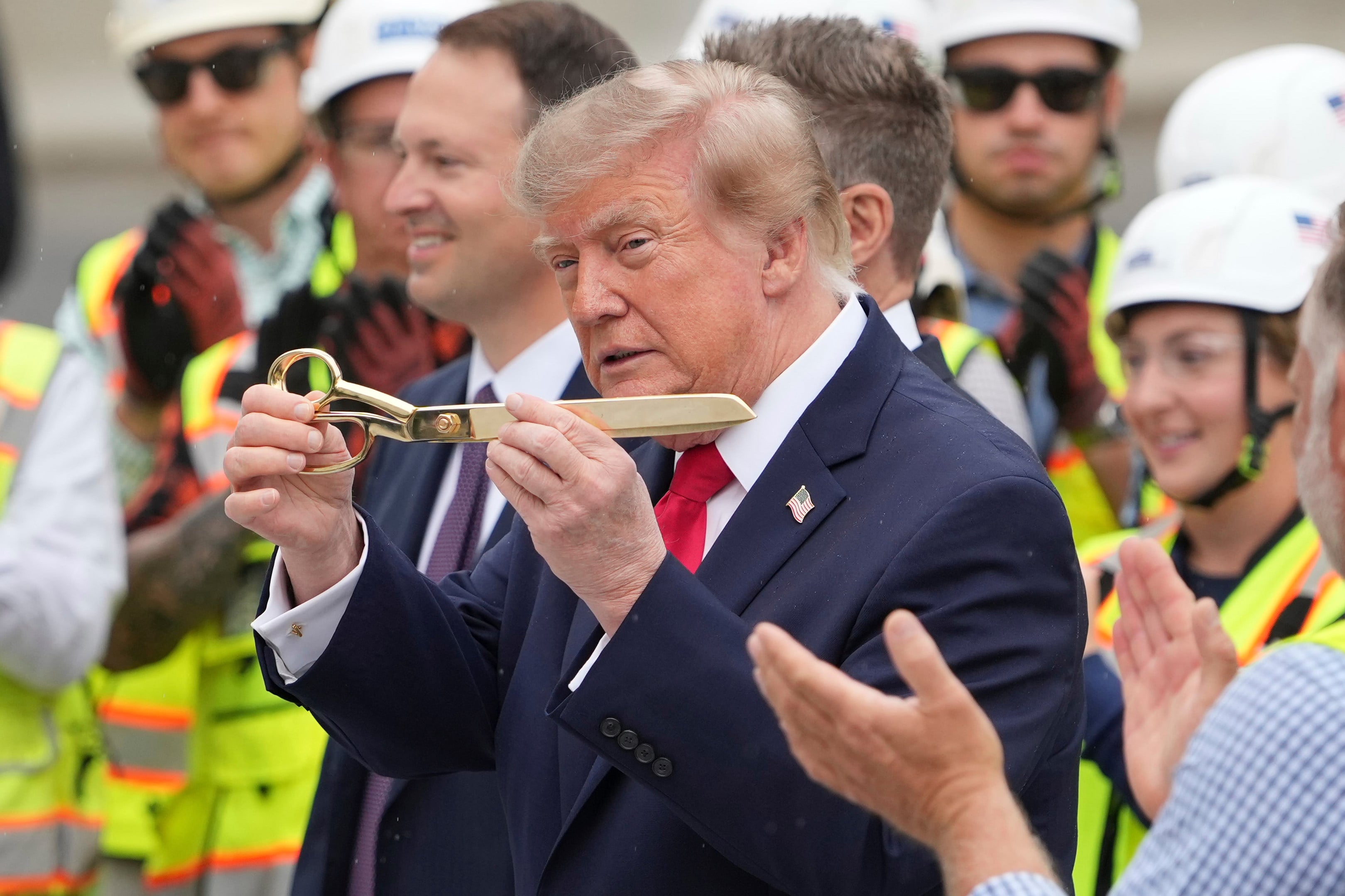 President Donald Trump used oversized gold scissors. Photo: AP