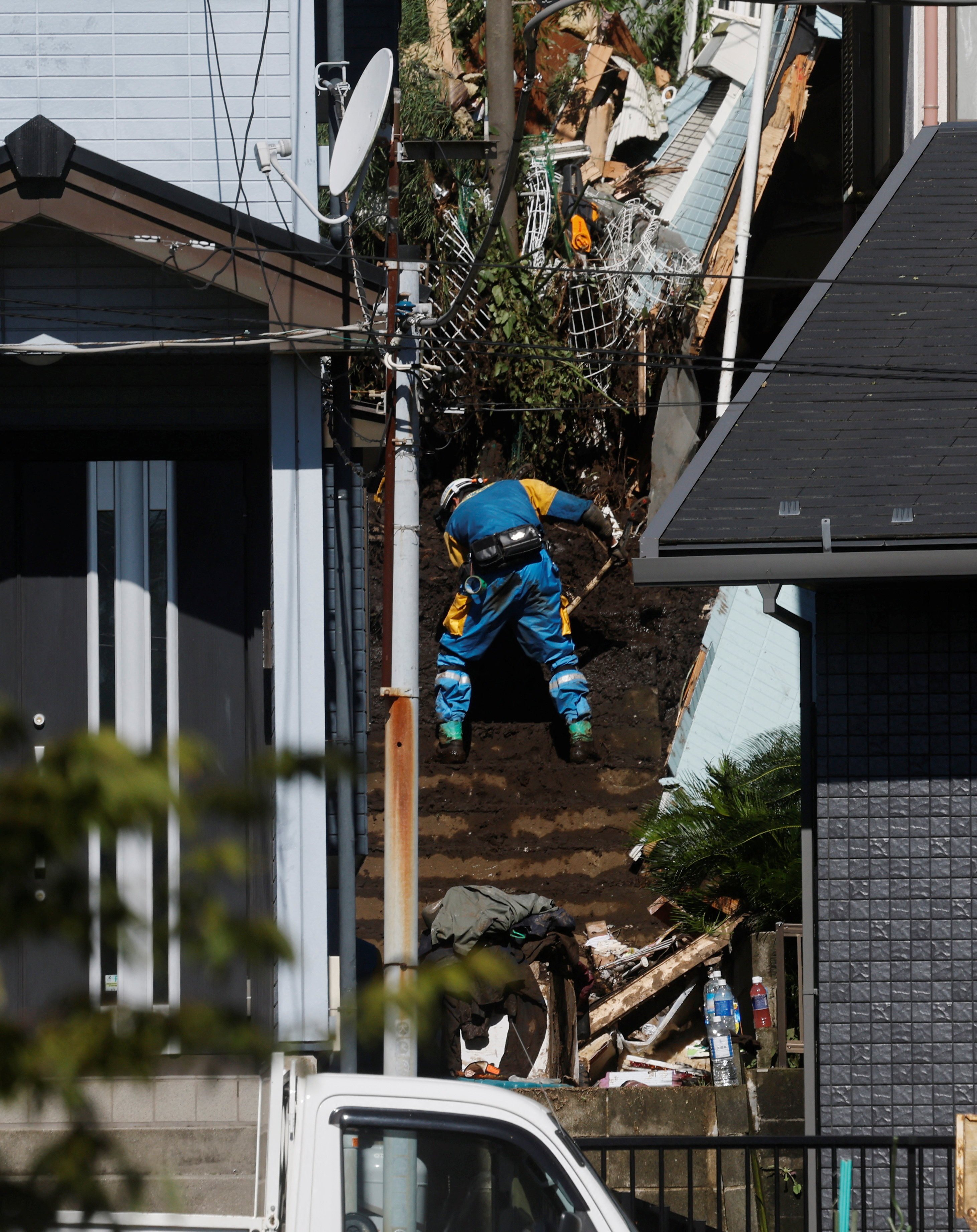 A rescuer clears debris while searching for a missing person at a house in Kanagawa prefecture on Tuesday. Photo: Reuters