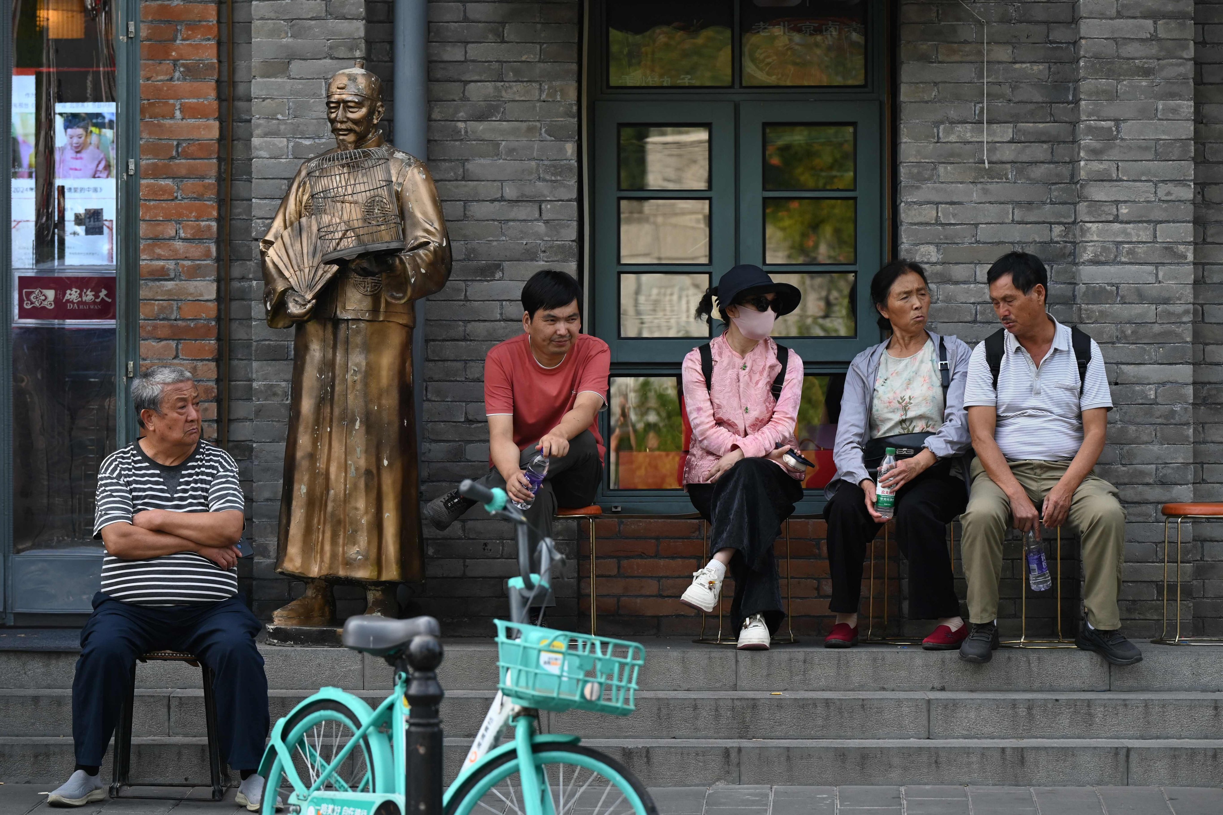 People wait outside a busy restaurant in Beijing on Monday. Photo: AFP