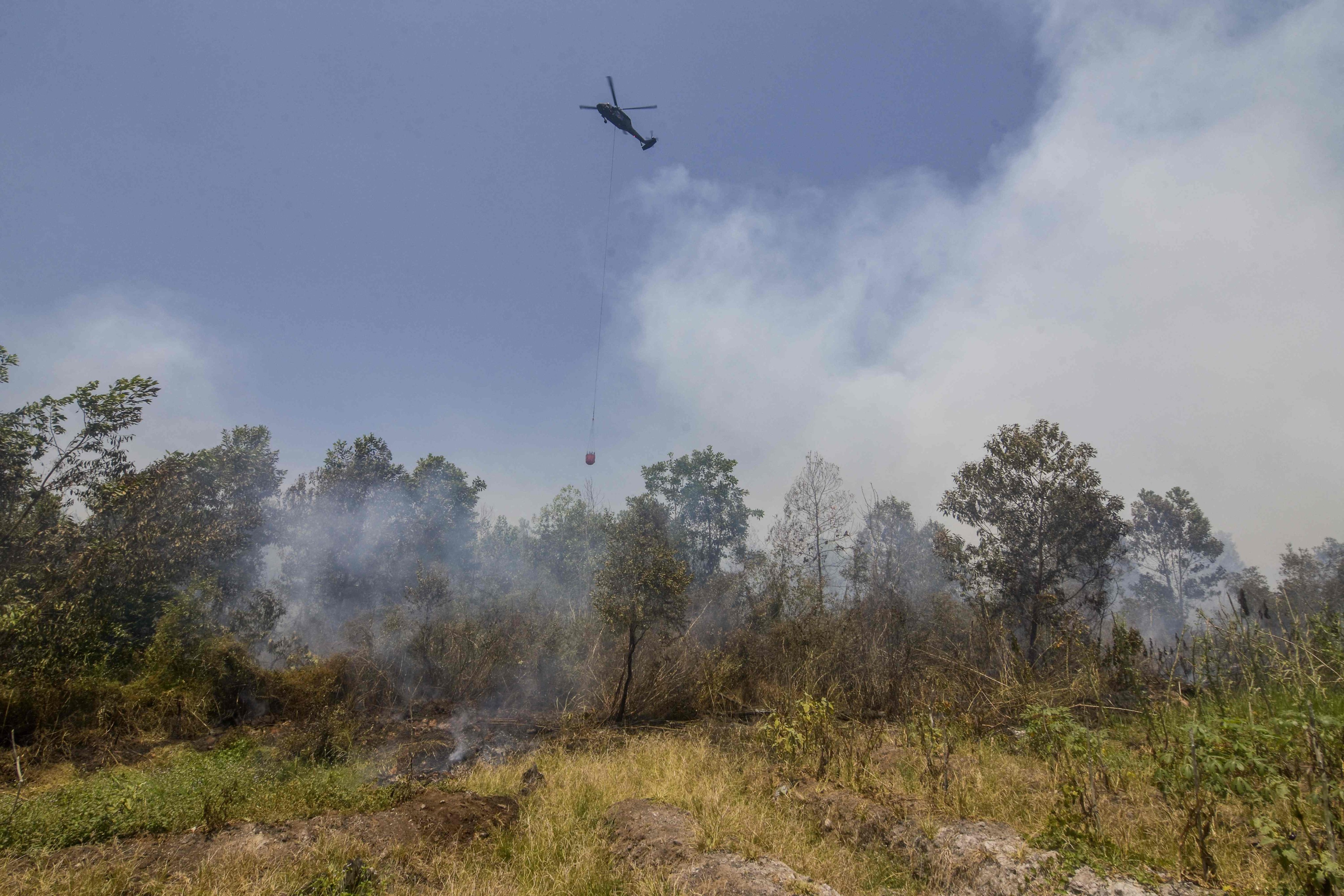 A helicopter drops water on forest fires in Banjarbaru, South Kalimantan province, Indonesia on Monday. Photo: AFP