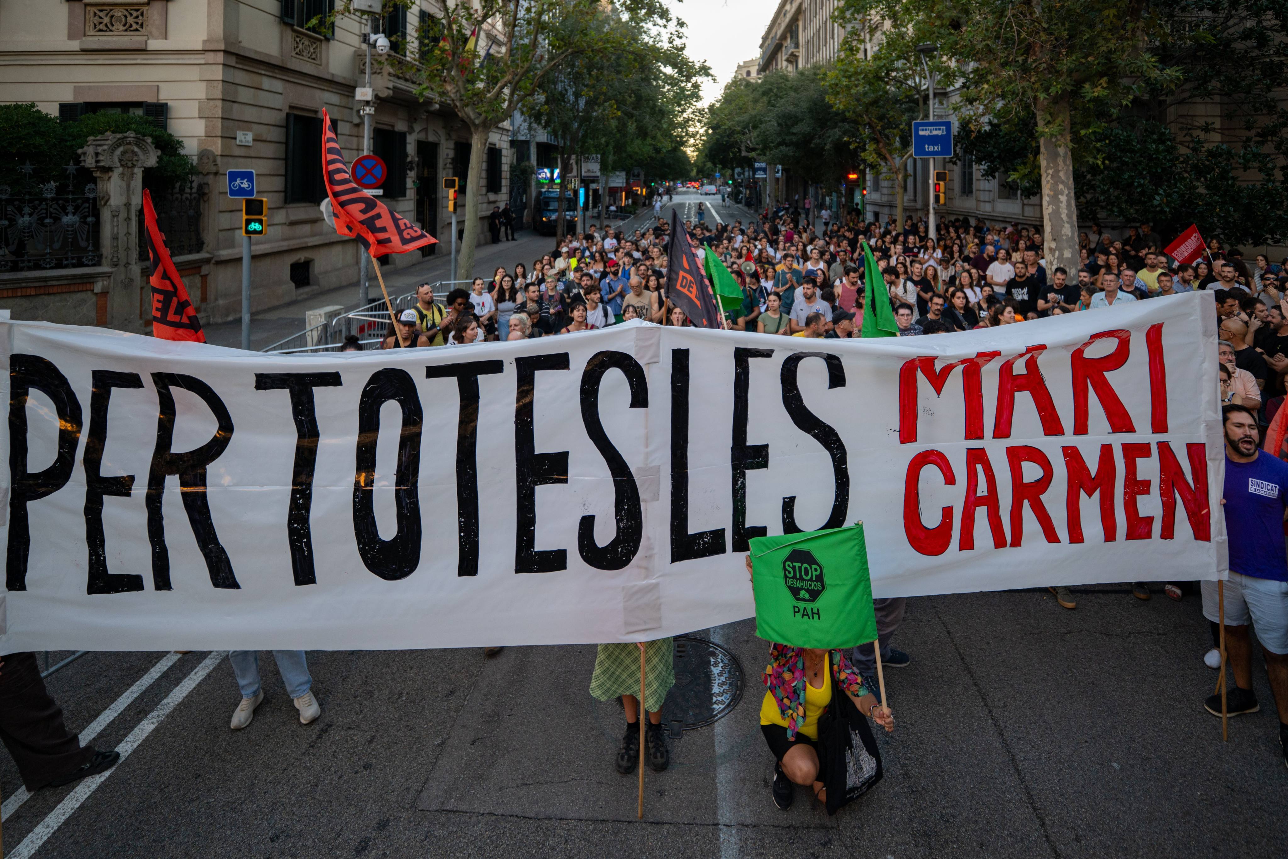 People hold a banner and flags during a rally in Madrid, Spain, following the eviction of 87-year-old woman Maricarmen Abascal. Photo: dpa