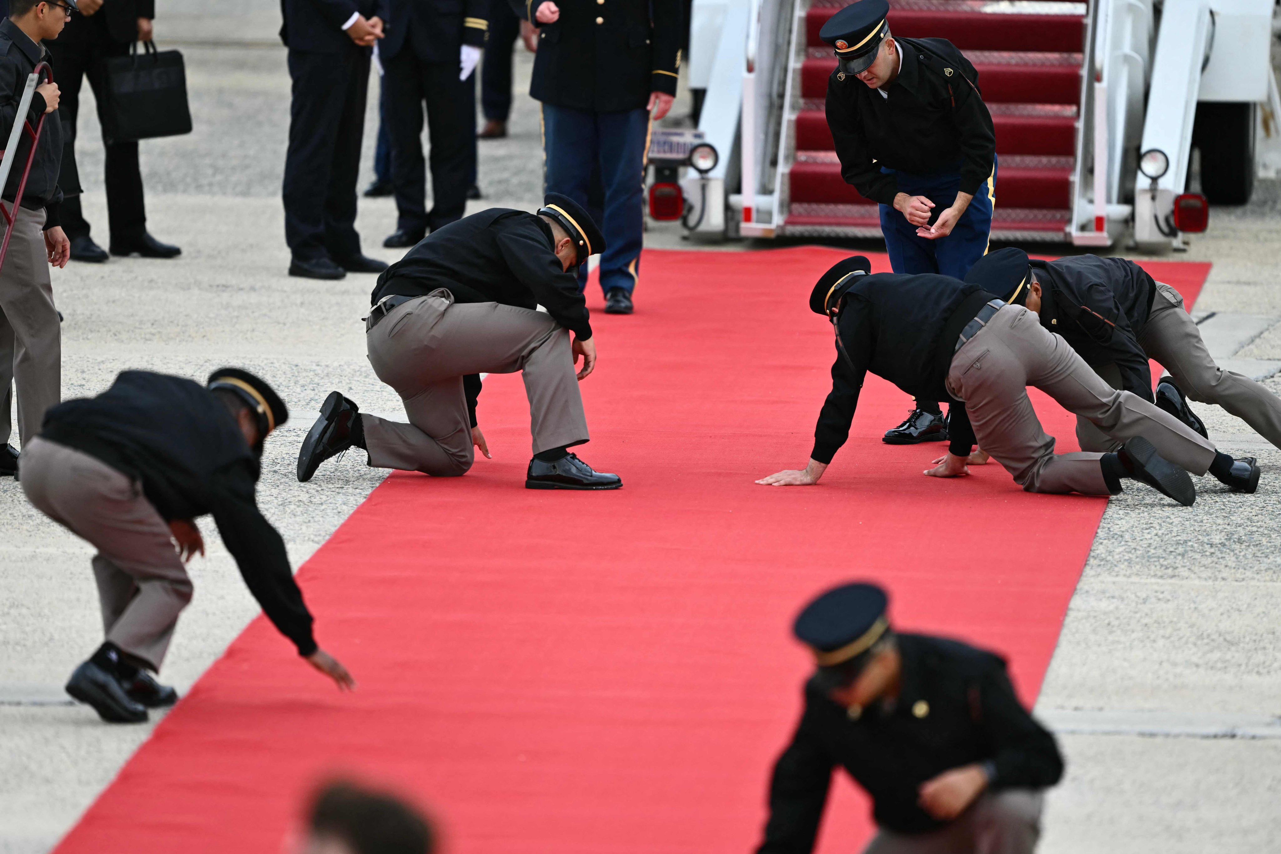 US military personnel adjust the red carpet at the foot of the stairs to the Air China plane carrying Chinese President Xi Jinping. Photo: AFP