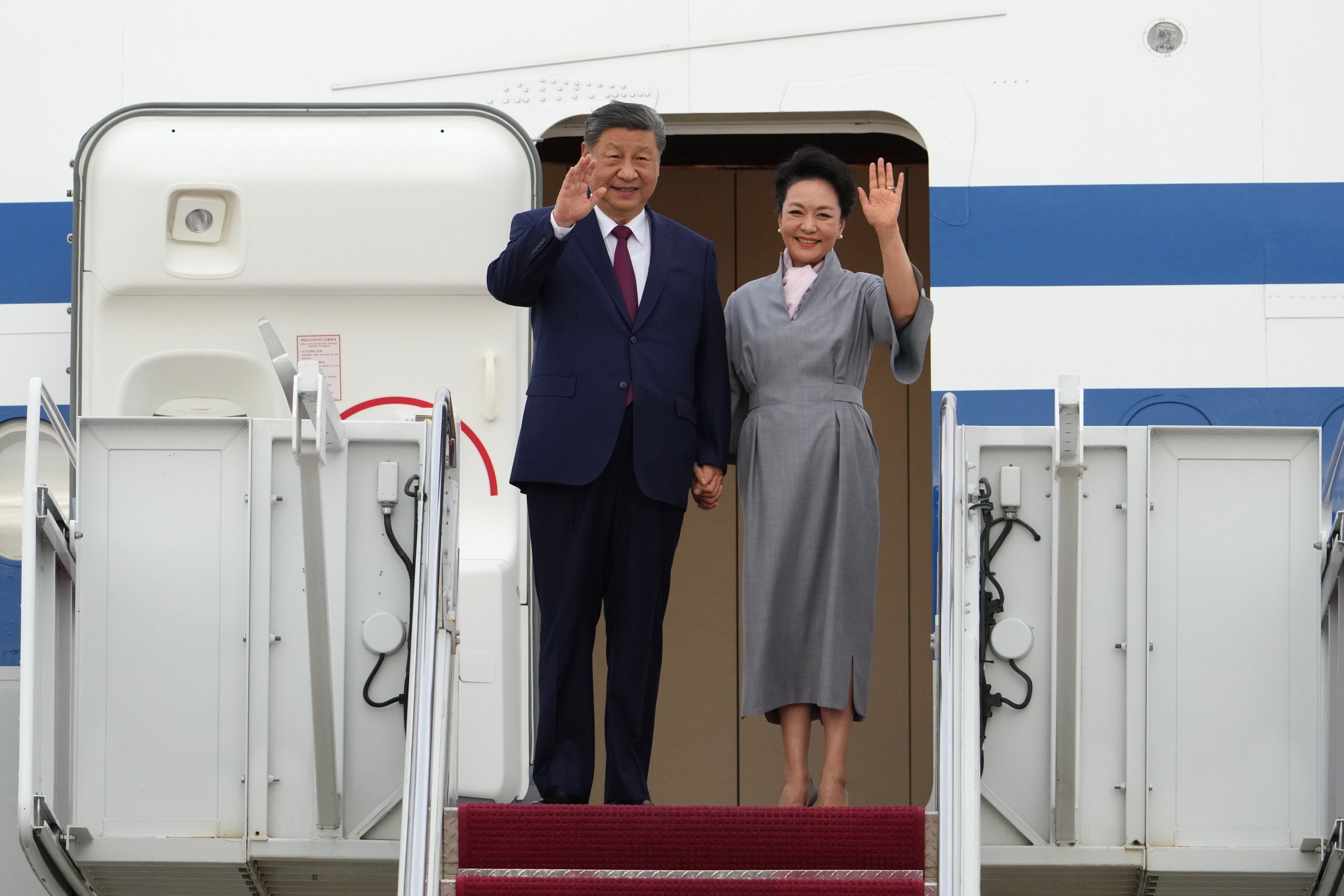China's President Xi Jinping and First Lady Peng Liyuan, wearing a grey dress cinched at the waist, wave as they arrive at Joint Base Andrews in Maryland to be greeted by US President Donald Trump and First Lady Melania Trump on September 23, 2026. Photo: AP