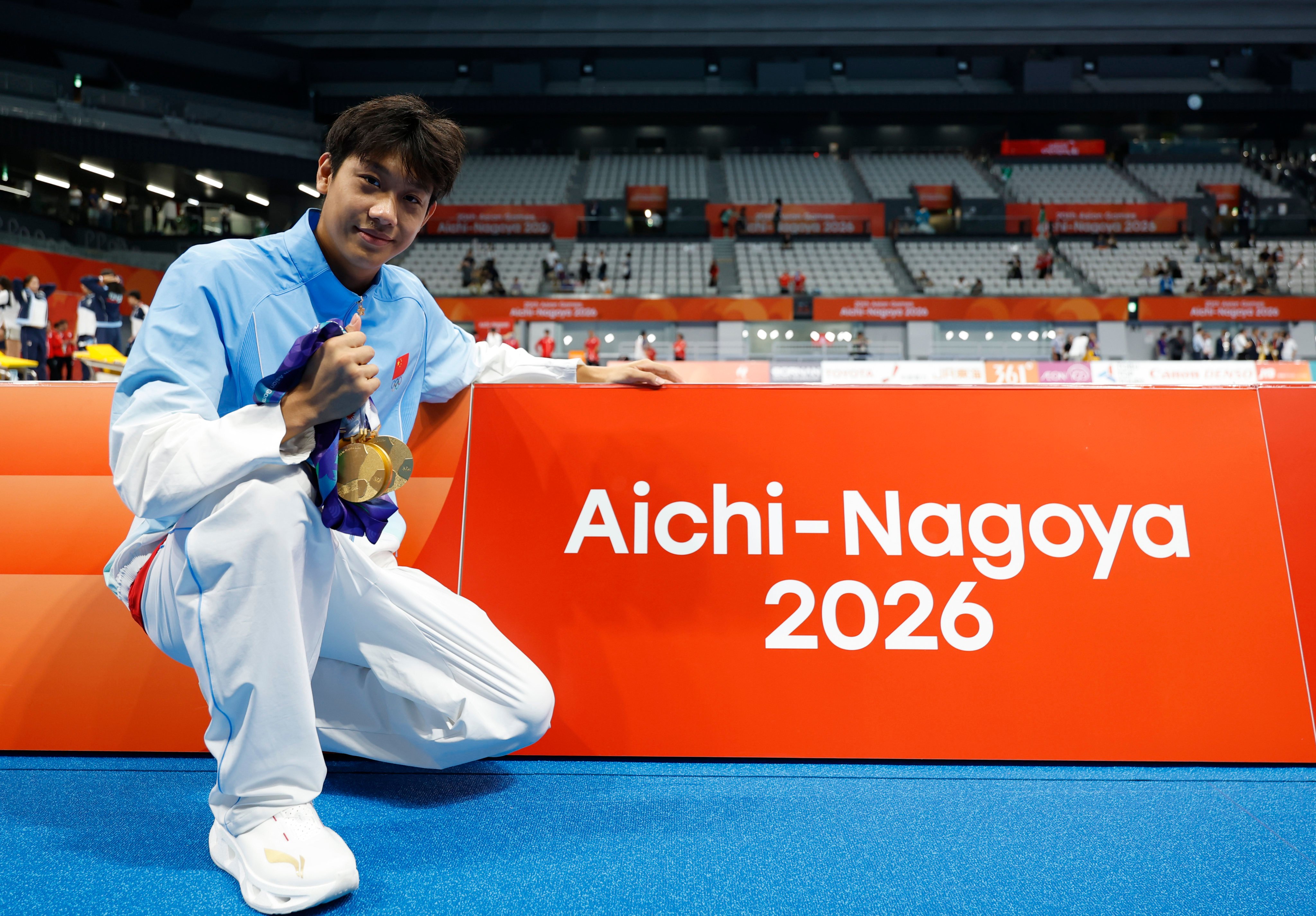 Zhang Zhanshuo poses with his record haul of gold medals after the 400m freestyle final on Friday. Photo: Xinhua