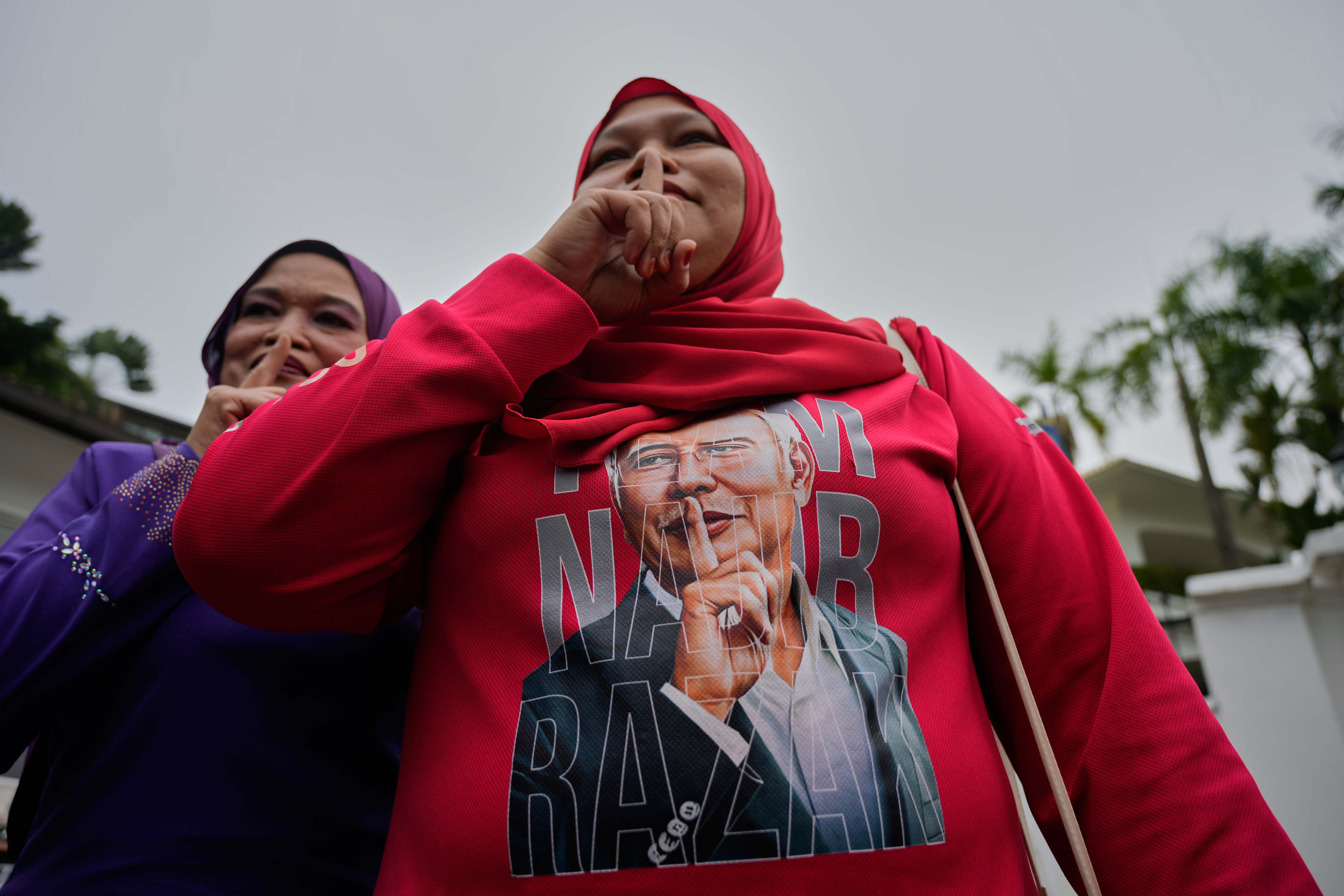 A supporter of former Malaysian Prime Minister Najib Razak gesture as she gathers outside his residence in Kuala Lumpur last Friday. Photo: AP