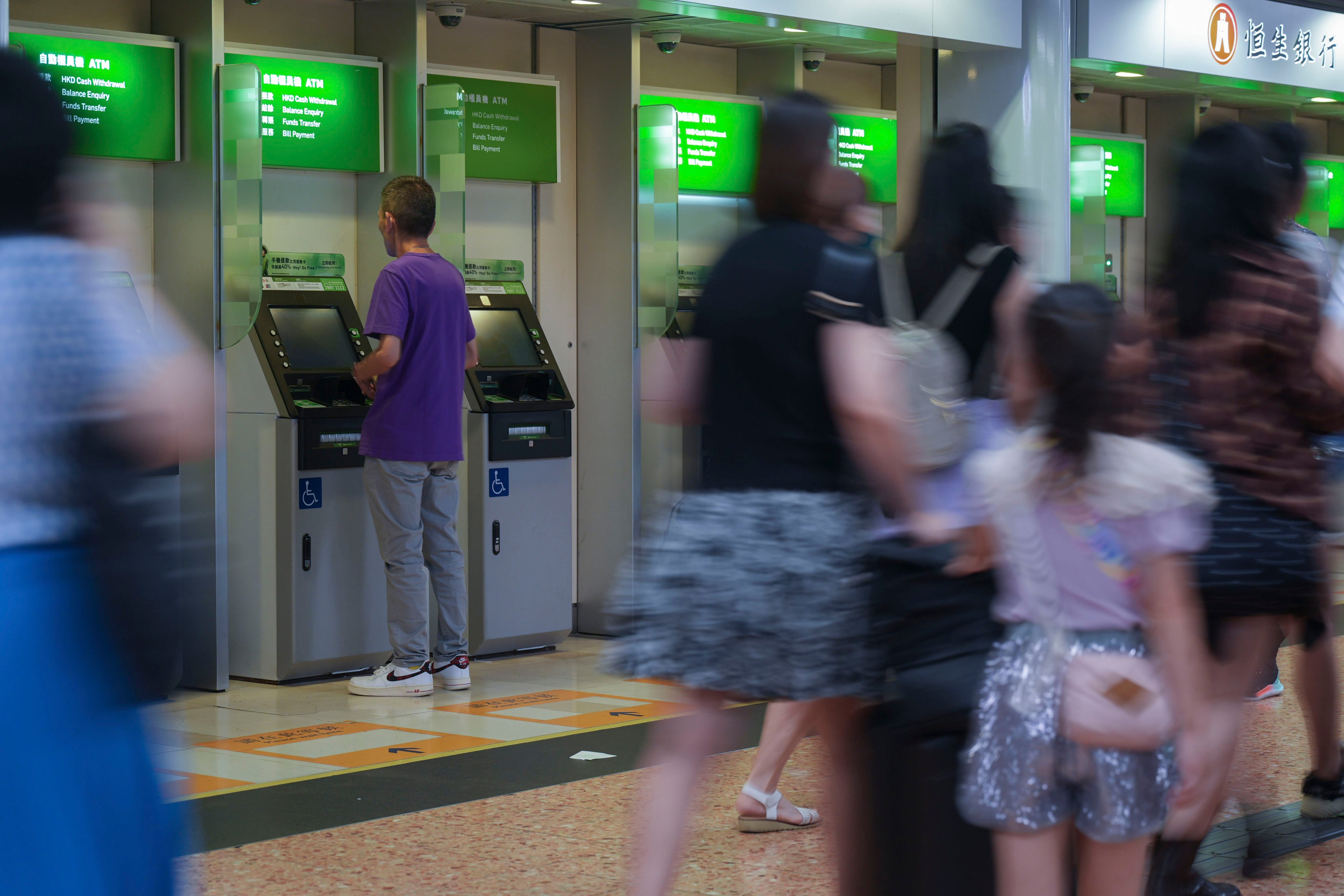 A person uses an ATM at a bank branch in Mong Kok. Photo: Eugene Lee