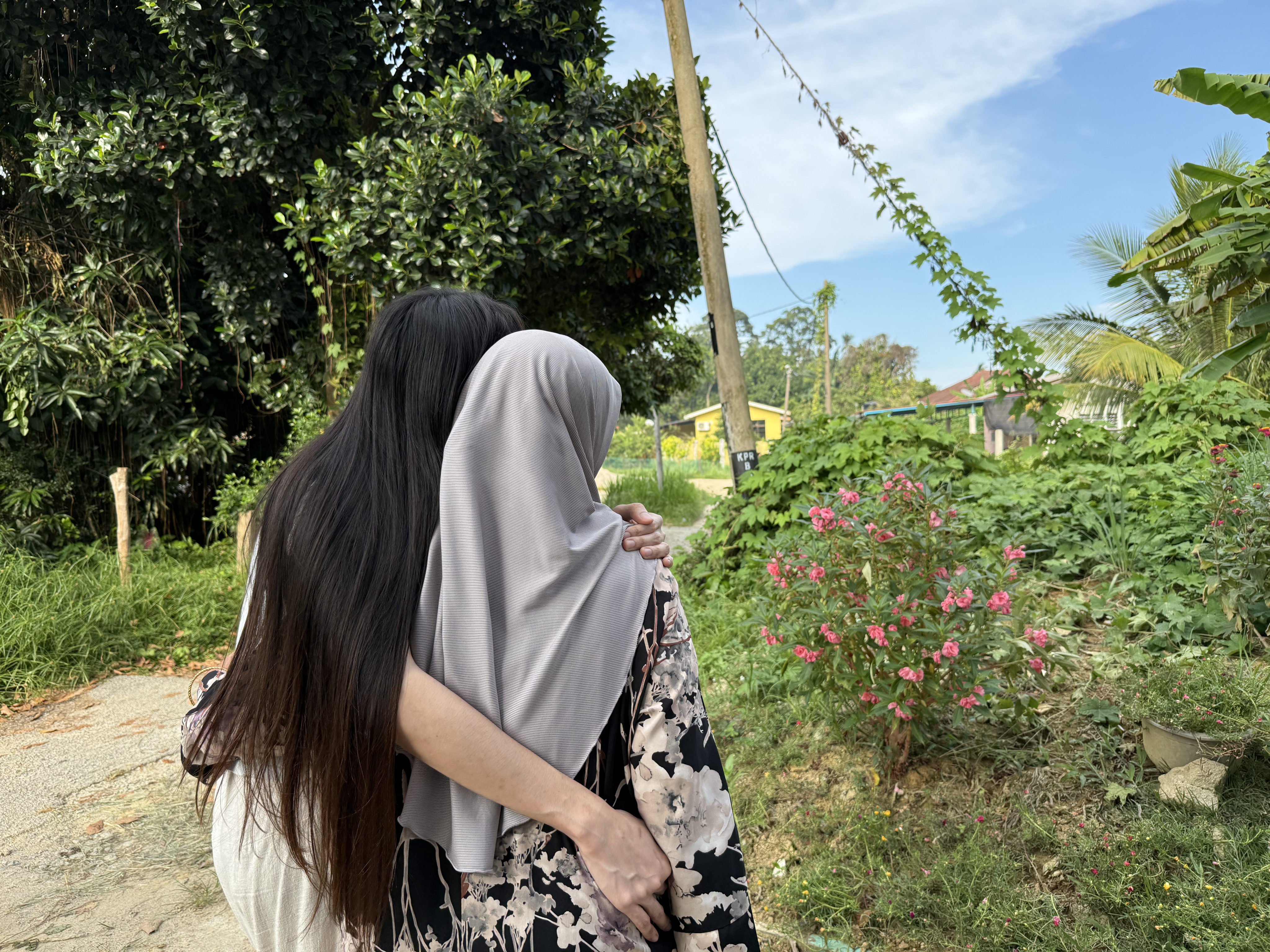 Hana* (left) embraces her mother outside their home in a village near Kota Bharu, Malaysia’s Kelantan state. Photo: Iman Muttaqin Yusof