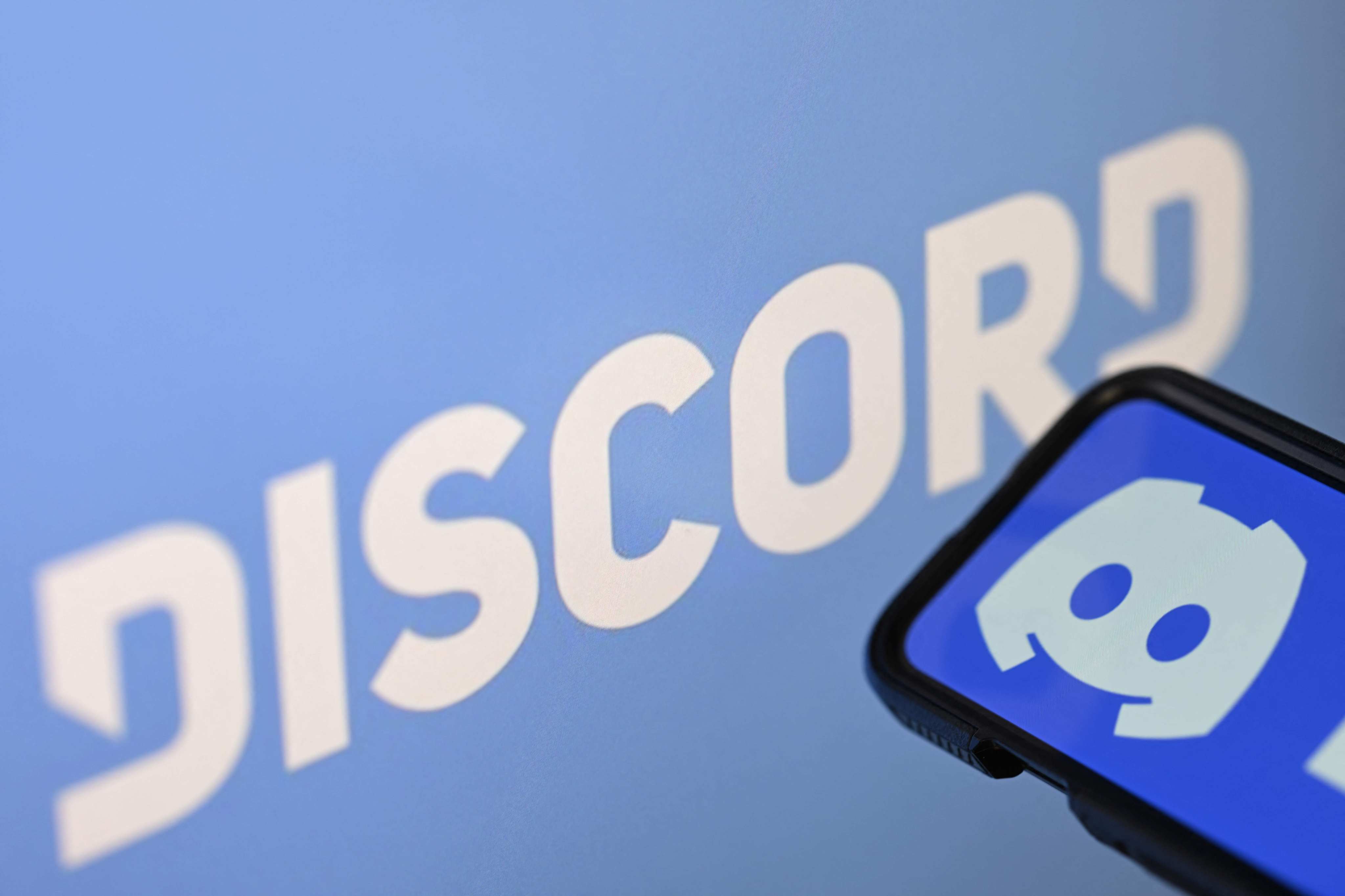 The logo of the US company Discord shown on a smartphone and a screen. Philippine officials said the app had servers associated with nihilistic violent extremism and grooming. Photo: AFP